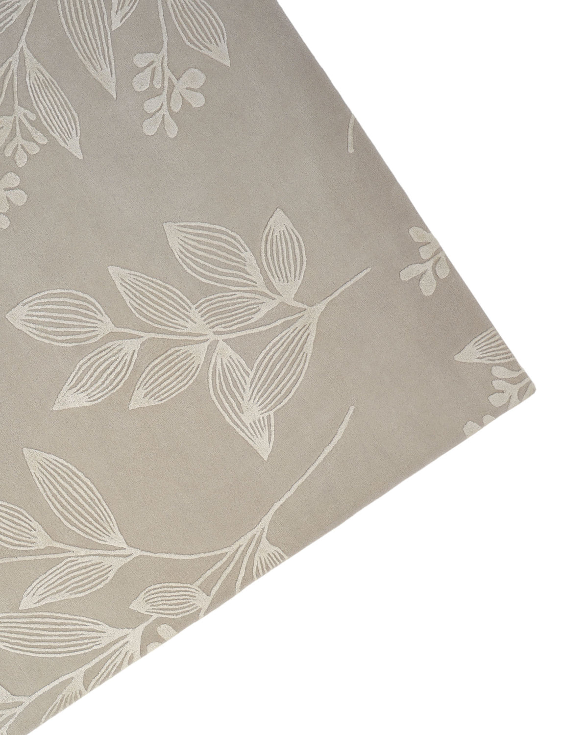 A corner of the RAMSHA HOME Natural Beige & Ivory Handmade Area Rug (HTWV-146) is shown from above, featuring a white botanical leaf and branch pattern against a white background.