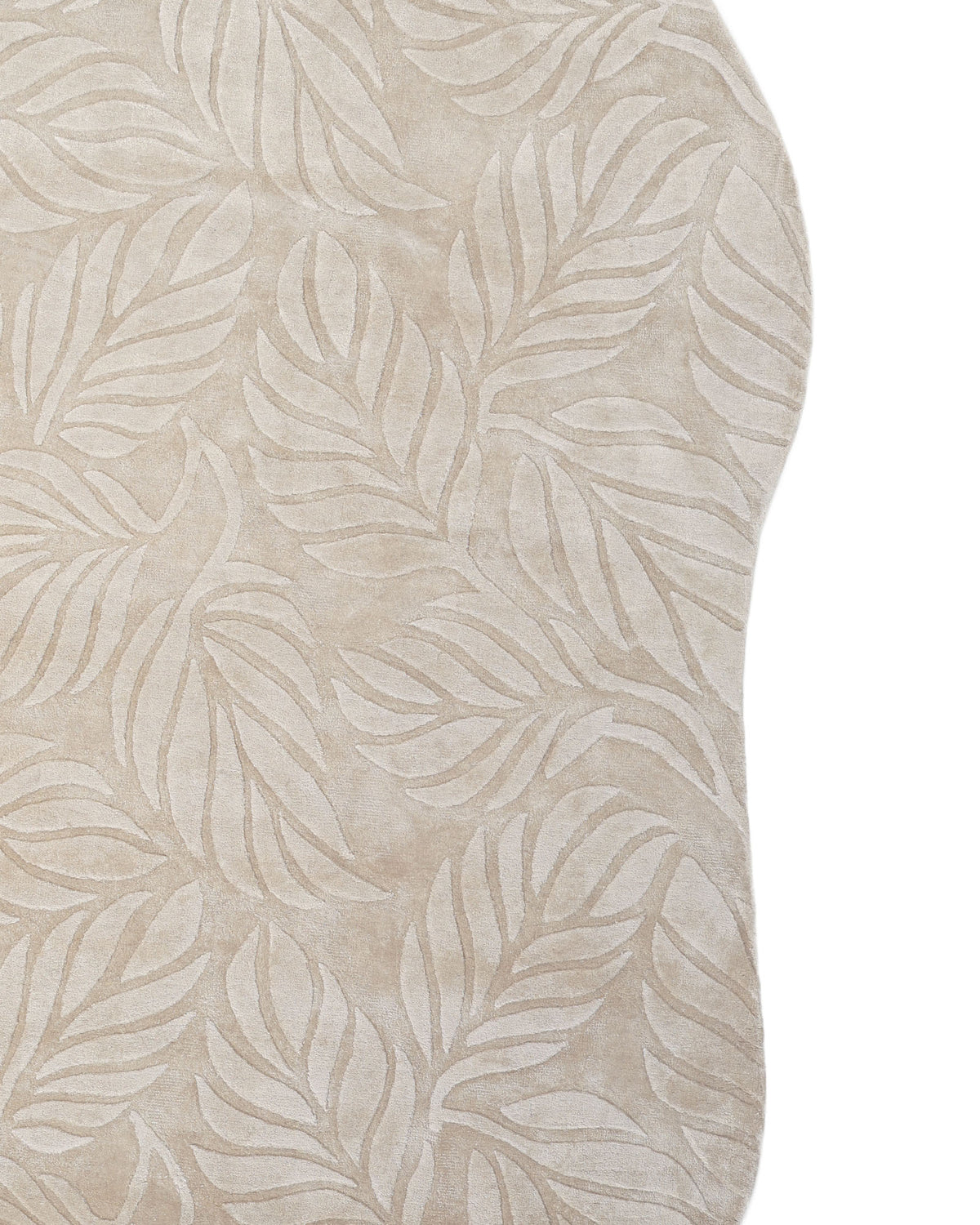 The RAMSHA HOME Beige Color Indoor Handmade Area Rug - HTV 15 showcases an irregular shape and a hand-tufted construction, featuring a raised leaf pattern in a subtly lighter beige shade, displayed against a white background.