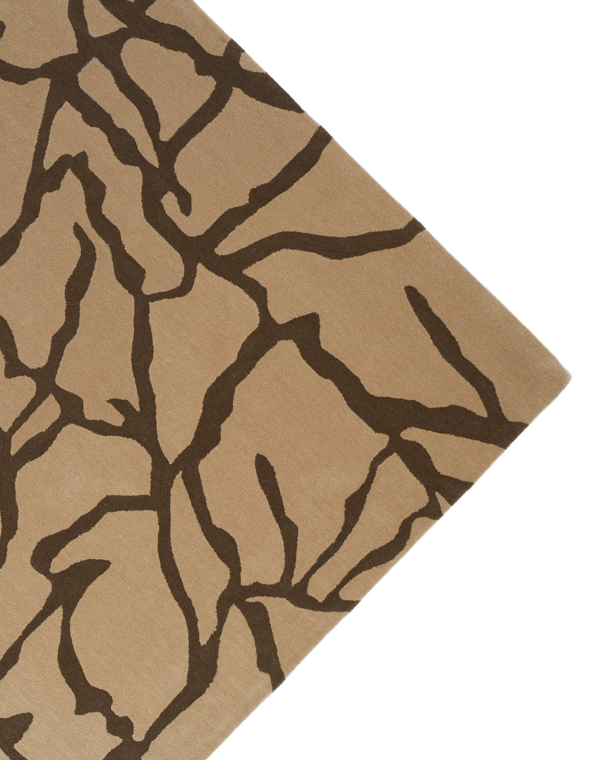 A Stunning Multi Color Fluffy Wool Handmade Rug by RAMSHA HOME (HTW 21, 202x292cm) is displayed at an angle, showing only one corner and featuring a beige hand-tufted design with an abstract dark brown pattern reminiscent of tree branches or cracks.