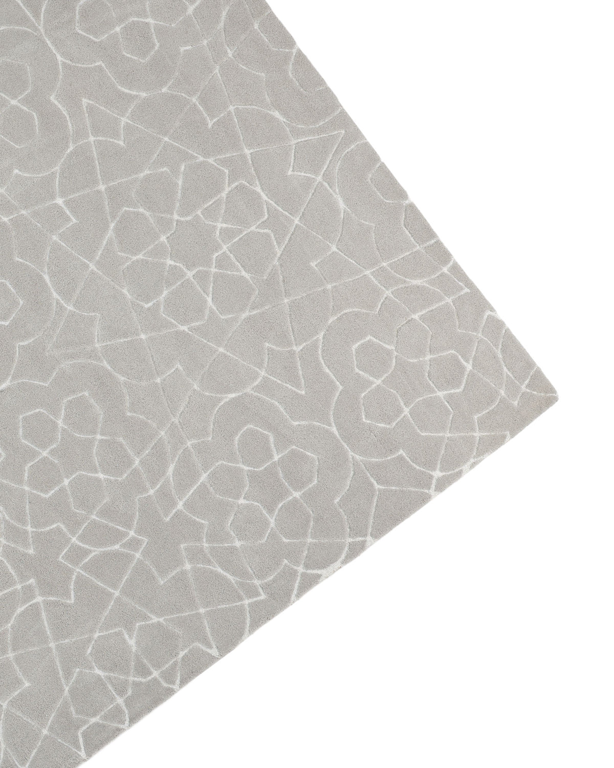 A close-up view of the RAMSHA HOME Home Decor Area Rug HTP-17, featuring hand-tufted construction in light gray with a subtle, intricate geometric pattern of white lines, shown angled with a corner visible in the frame.