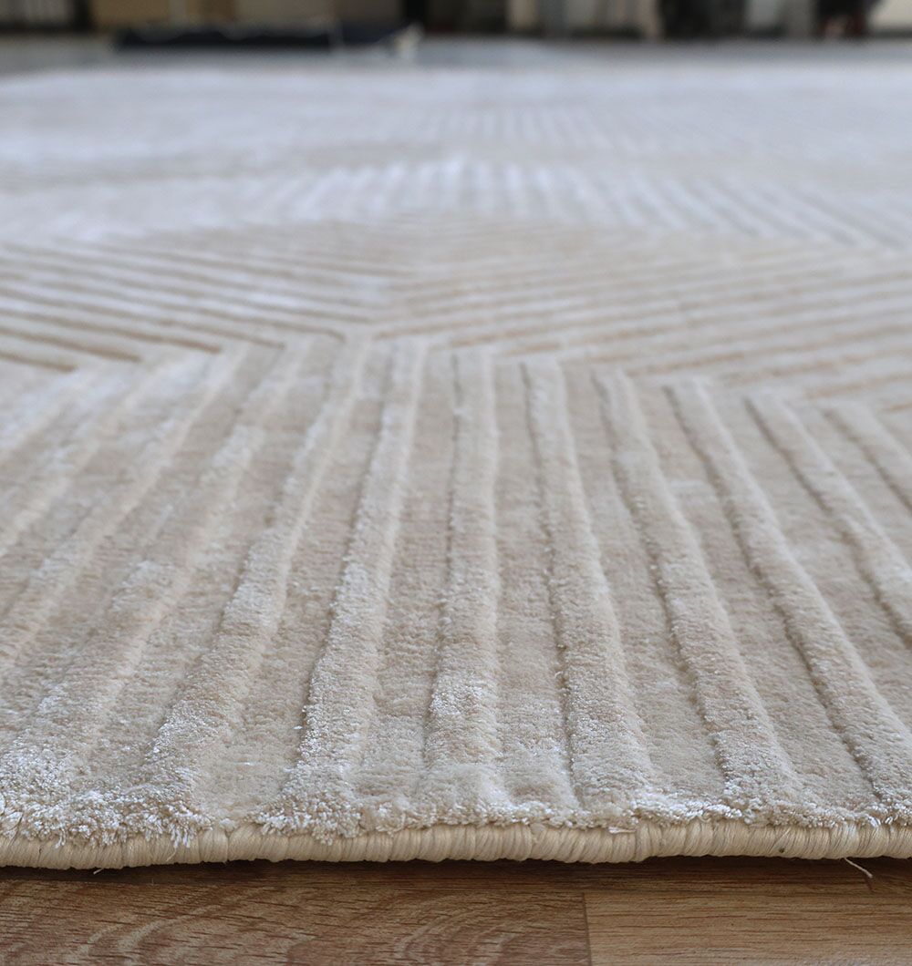 Close-up of the Geometric Hex Line Patterned Handmade Area Rug - LKH-08, featuring a beige hue, raised soft viscose surface, and intricate geometric details. Displayed on a wooden floor, it highlights refined, textured elegance.