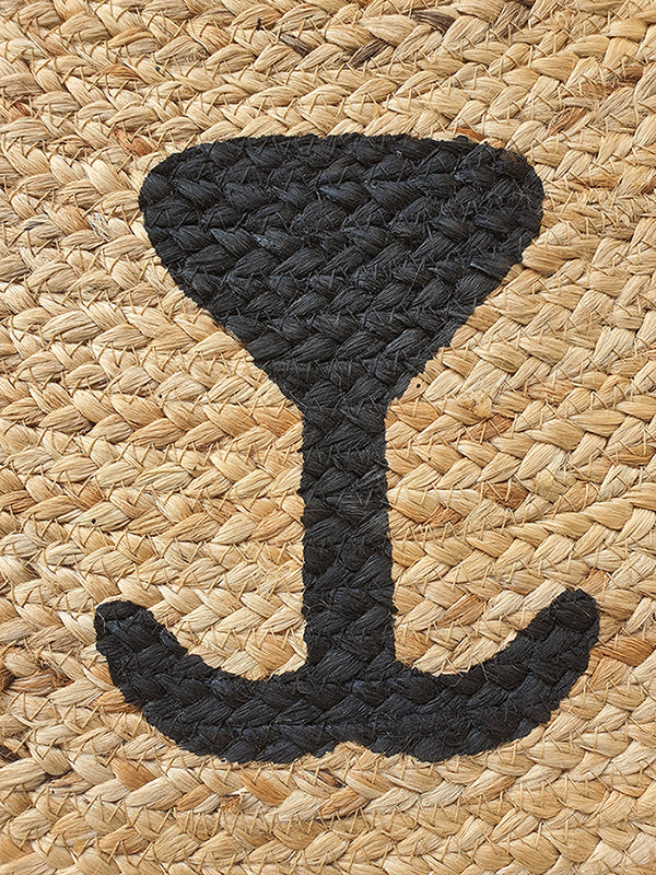 The Amazing Handmade Jute Round Braided Rug - BR 078 by RAMSHA HOME features a large black anchor symbol at the center, set on a natural tan woven jute background.