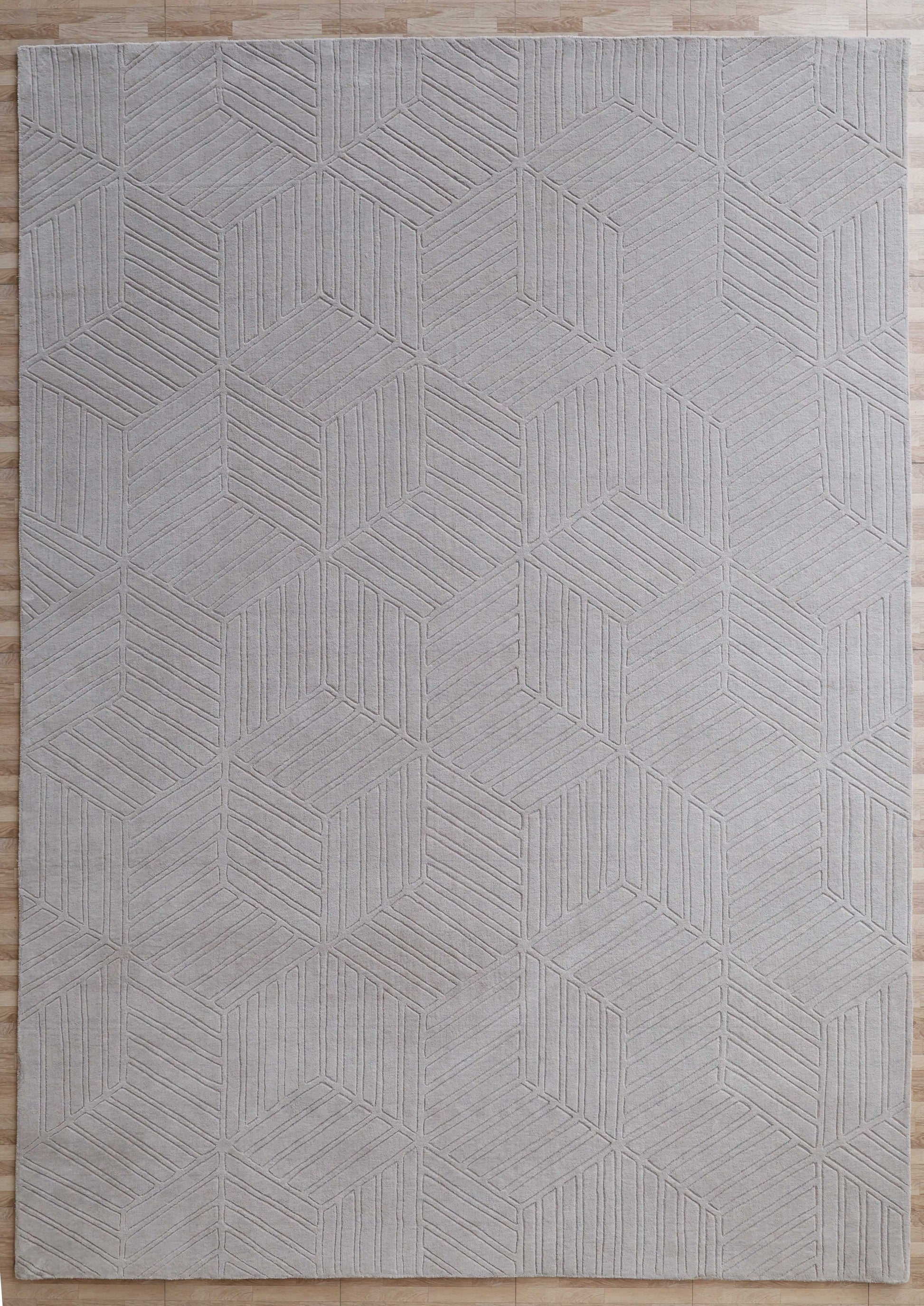 The RAMSHA HOME Light Grey Handmade Area Rug (300x400 cm, LKH-044) features a subtle geometric interlocking cube and line pattern, perfect for placement on light wooden floors.