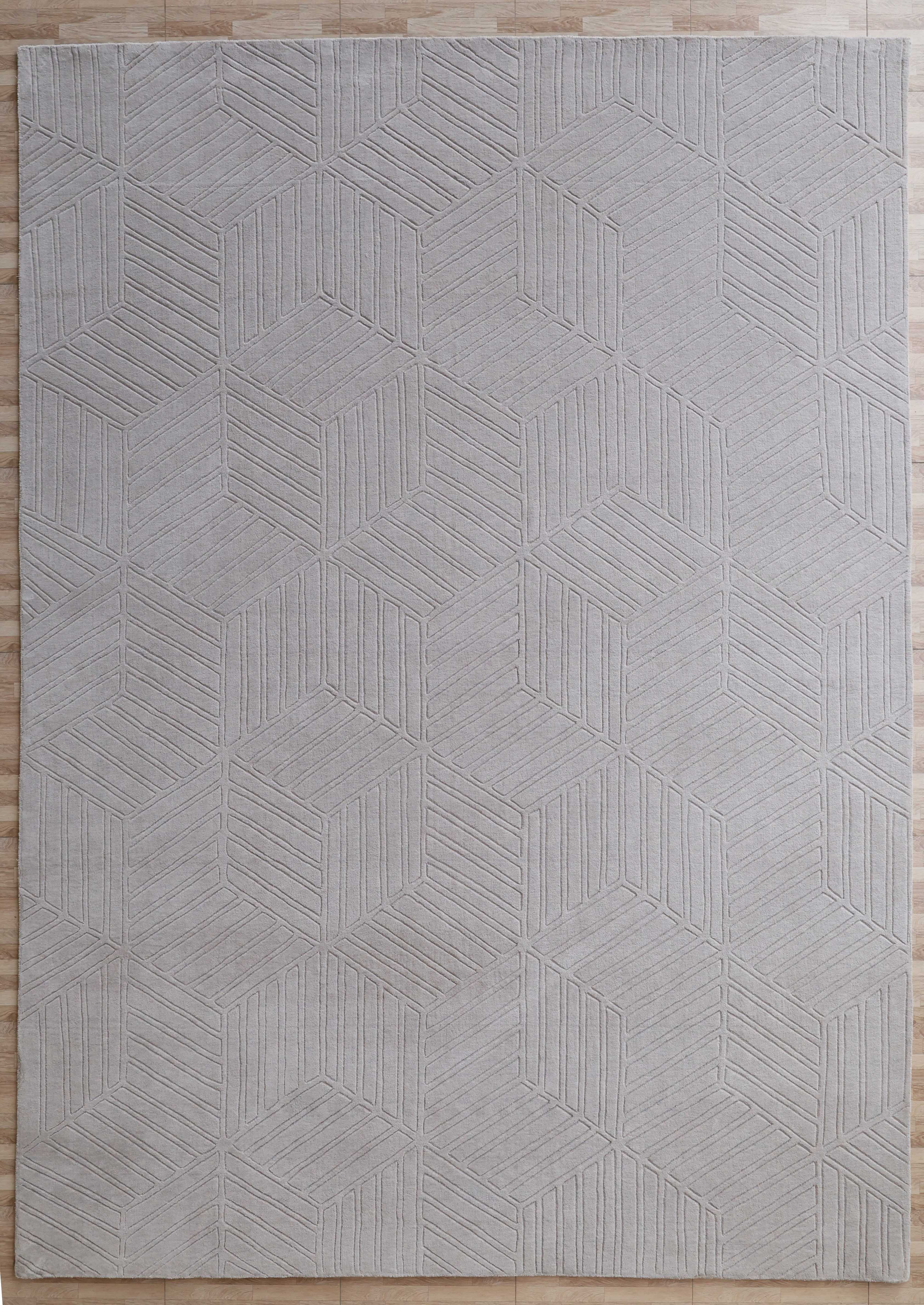 The RAMSHA HOME Light Grey Handmade Area Rug (300x400 cm, LKH-044) features a subtle geometric interlocking cube and line pattern, perfect for placement on light wooden floors.