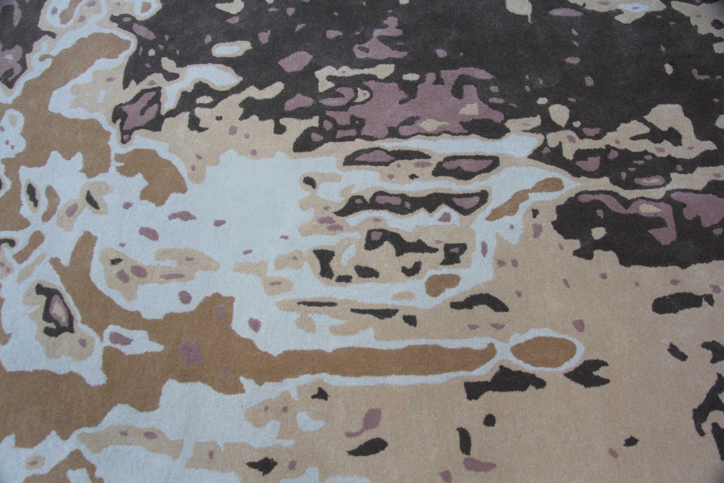 The Amazing Multi Color Handmade Rug - HTW 53 (200x300cm) by RAMSHA HOME features an abstract design with beige, brown, cream, mauve, and black shapes on a textured surface, offering a modern camouflage or painting-like look.