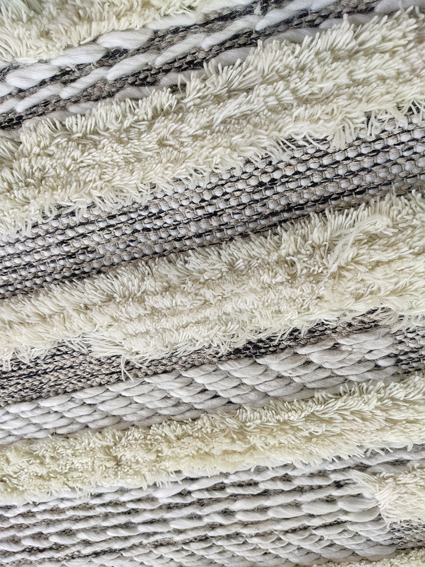 Close-up of the RAMSHA HOME Fringes Woven Rug (SR-053) featuring cream shaggy fibers and tightly braided patterns in neutral tones, creating a layered, tactile look perfect for living rooms or bedrooms.