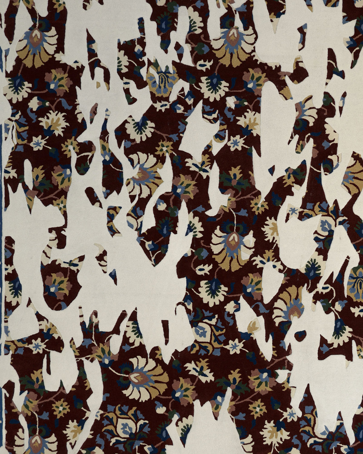 A RAMSHA HOME Multi Color Handmade Area Rug (HTW 111, 300X400 cm) features a traditional floral design in shades of blue, beige, and brown and is partially obscured by irregular white shapes, creating a fragmented, abstract effect.