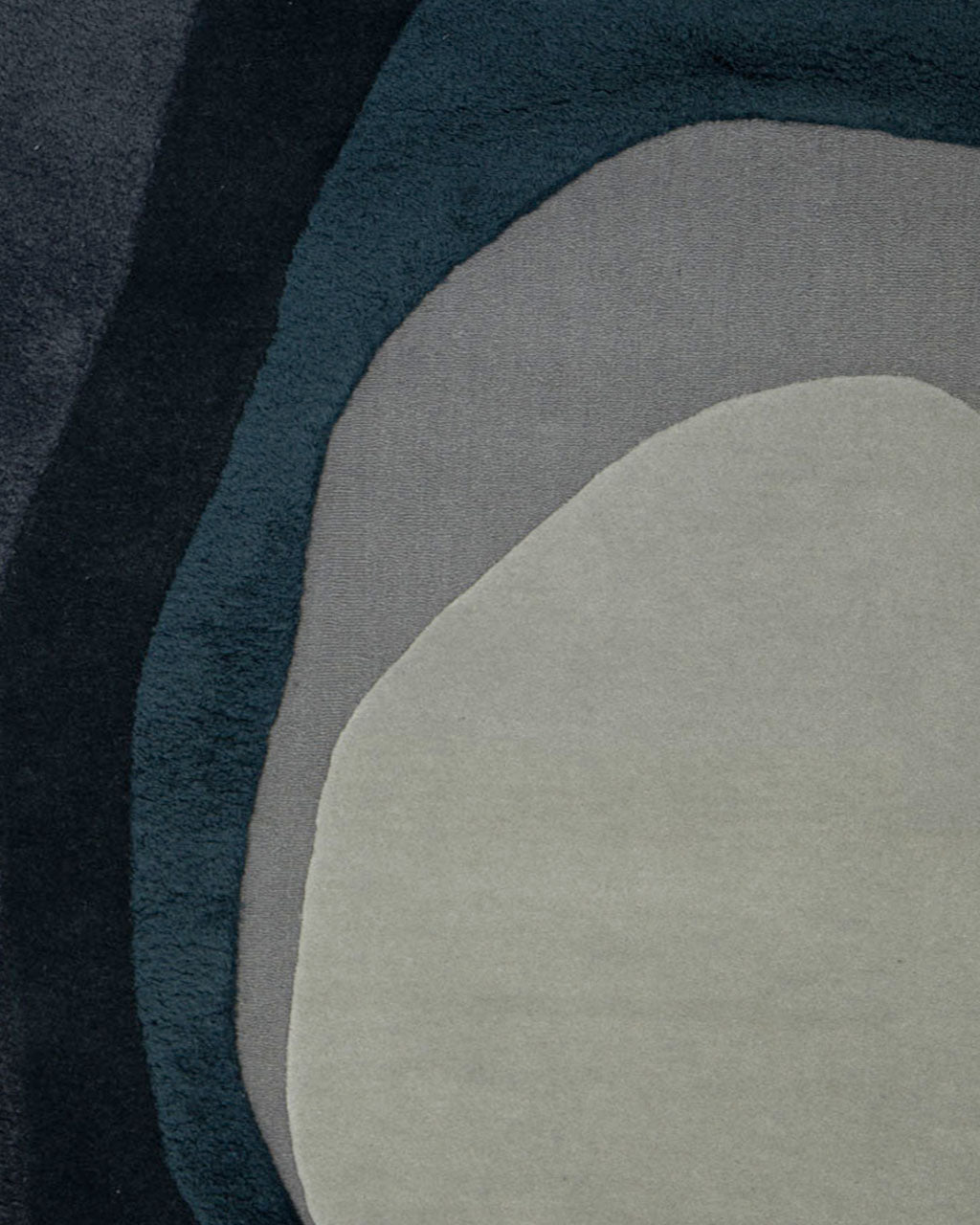 Introducing the Handmade Layered Abstract Shaped Rug HTW 131 (200 x 300 cm) by RAMSHA HOME, featuring an abstract pattern with irregular, rounded layers in shades of gray, dark blue, and green reminiscent of a geode cross-section or a topographic map. This modern area rug boasts soft textures with subtle raised details and an irregular shape that adds a distinctive touch to any room.