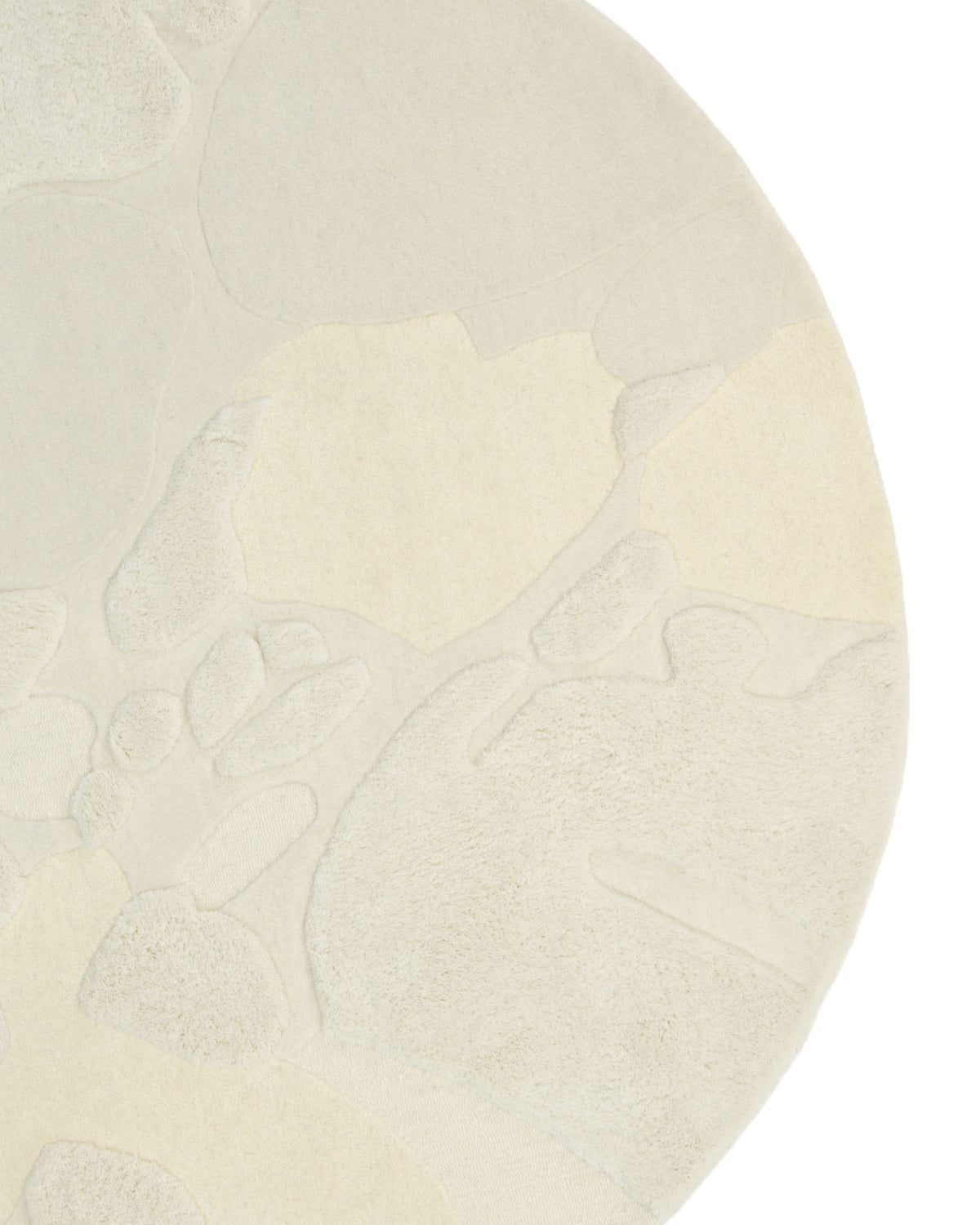 A close-up of the RAMSHA HOME Creative Multi Color Wool & Cotton Handmade Rug - HTW 69 (200x300cm) reveals its unique round, irregular shape and a subtle abstract pattern in various textures and shades of cream and off-white. Expertly hand-tufted from wool and cotton, this rug brings understated elegance to any space.