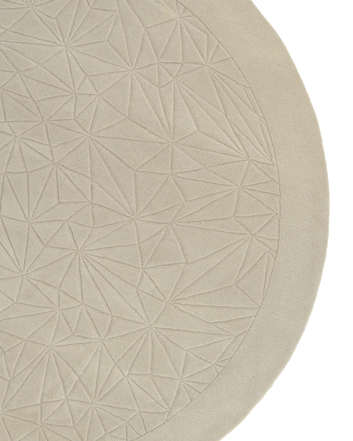 A close-up of the RAMSHA HOME Luxury Home Decor Handmade Carpet – HTW-65 showcases its round, hand-tufted design featuring a beige surface embellished with an embossed geometric triangular pattern.