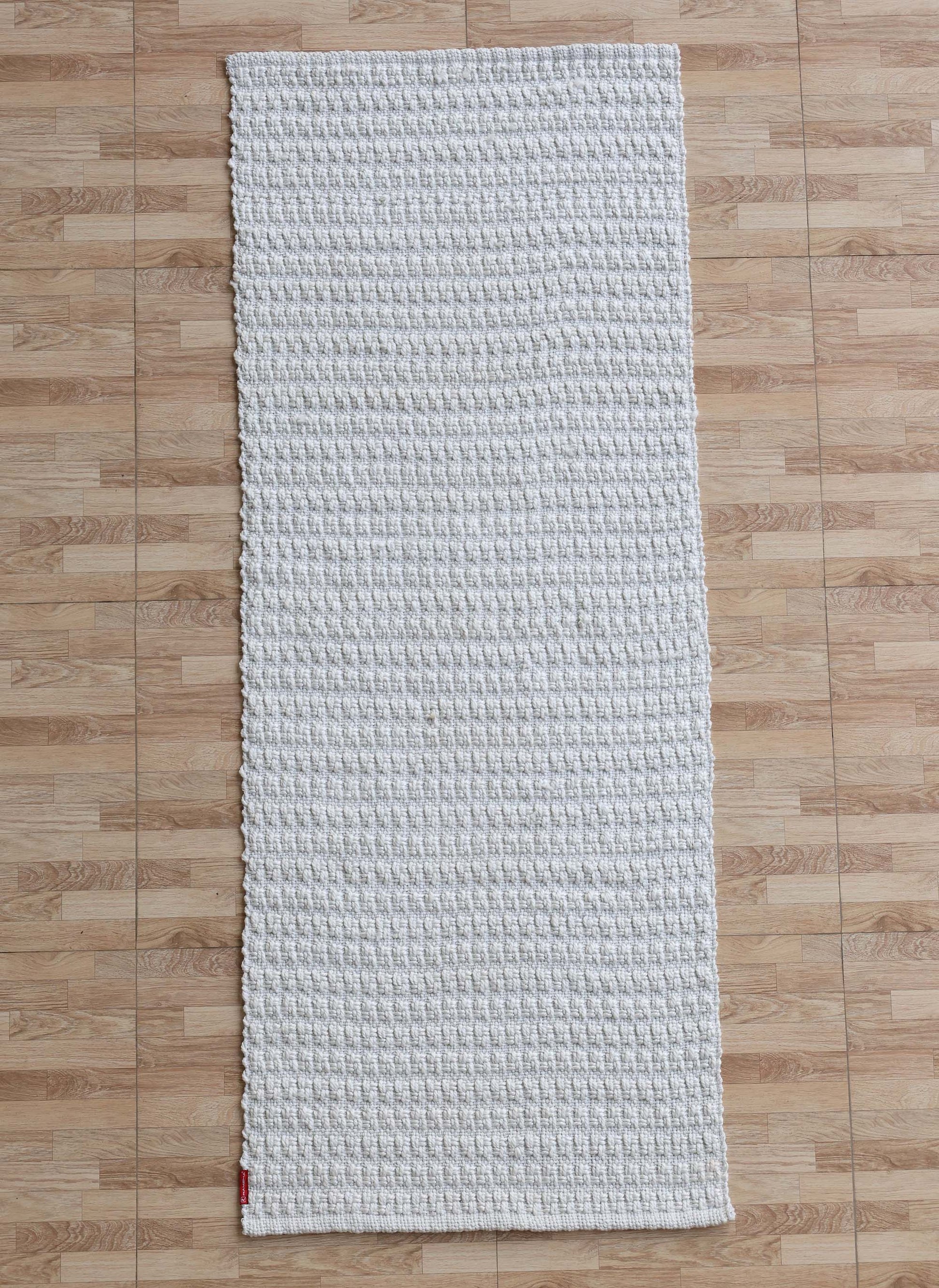The RAMSHA HOME Handmade Cream Natural Color Hand Woven Area Rug WR-039, featuring a rectangular shape and soft texture, is displayed atop a light brown wooden floor—an elegant addition of artisanal home décor.