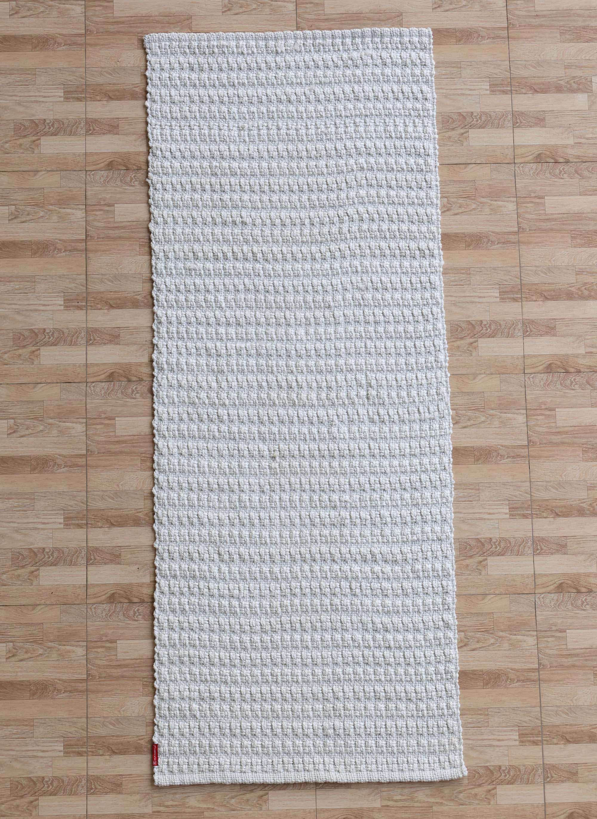 The RAMSHA HOME Handmade Cream Natural Color Hand Woven Area Rug WR-039, featuring a rectangular shape and soft texture, is displayed atop a light brown wooden floor—an elegant addition of artisanal home décor.