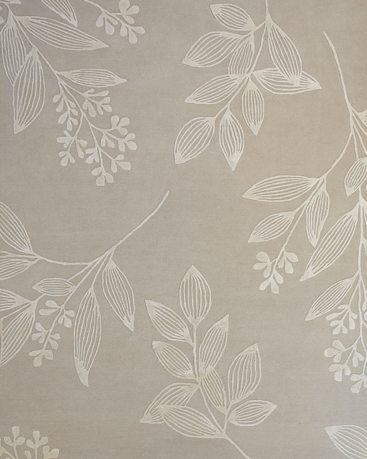 Experience the timeless elegance of the Natural Beige & Ivory Handmade Area Rug (HTWV-146) by RAMSHA HOME, featuring a subtle beige fabric adorned with an intricate pattern of white, embroidered leaves and branches in a delicate, repeating design—evoking the beauty of a finely crafted leaf motif.