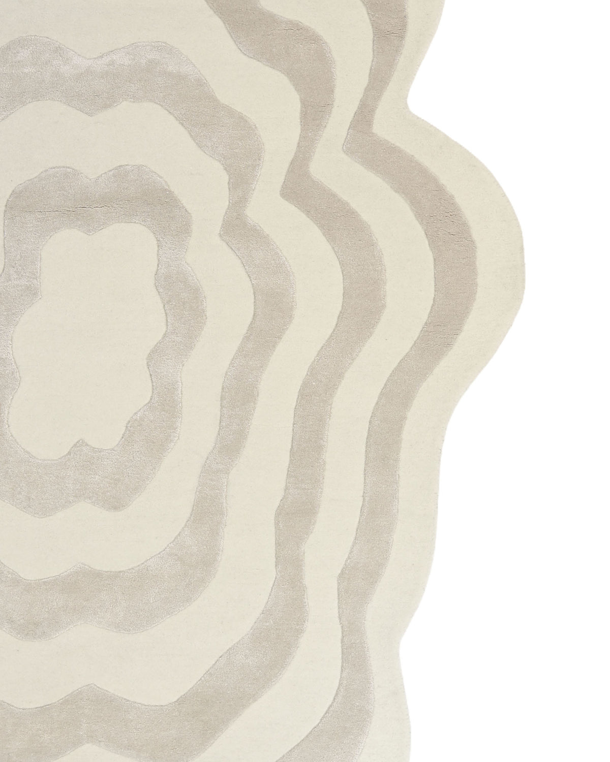 The RAMSHA HOME Beige & Cream Wavy Handmade Area Rug – HTWV-144 features uneven, wavy, concentric shapes in soft beige and cream tones, forming organic, irregular rings reminiscent of a topographic map. This hand-tufted viscose rug is finished with a distinctive scalloped border along the right edge for added visual interest.