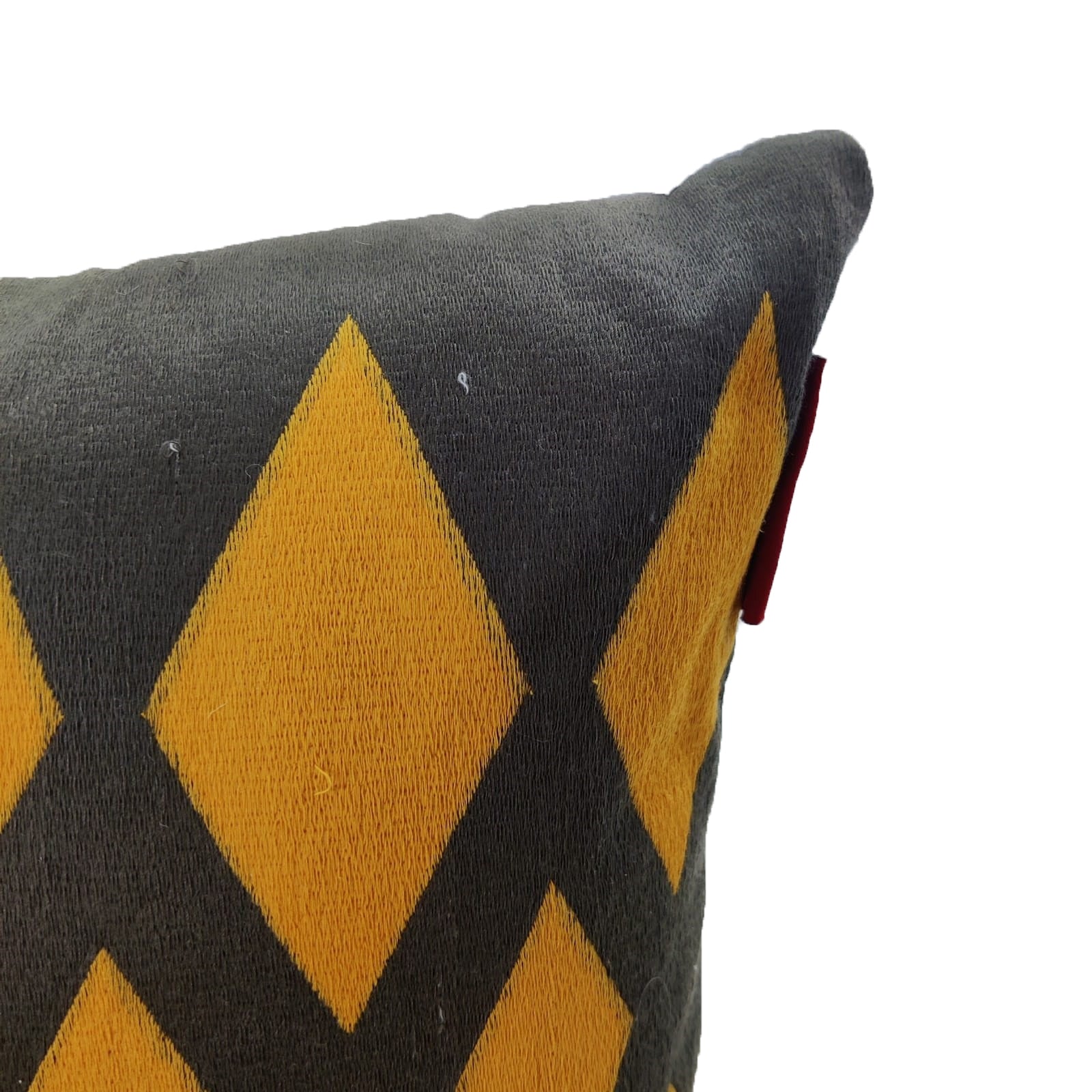 A close-up of RAMSHA HOME’s Embroidery Cotton Cushion CS-258, featuring a yellow diamond pattern and a small red side tag, is shown from the upper corner against a white background.