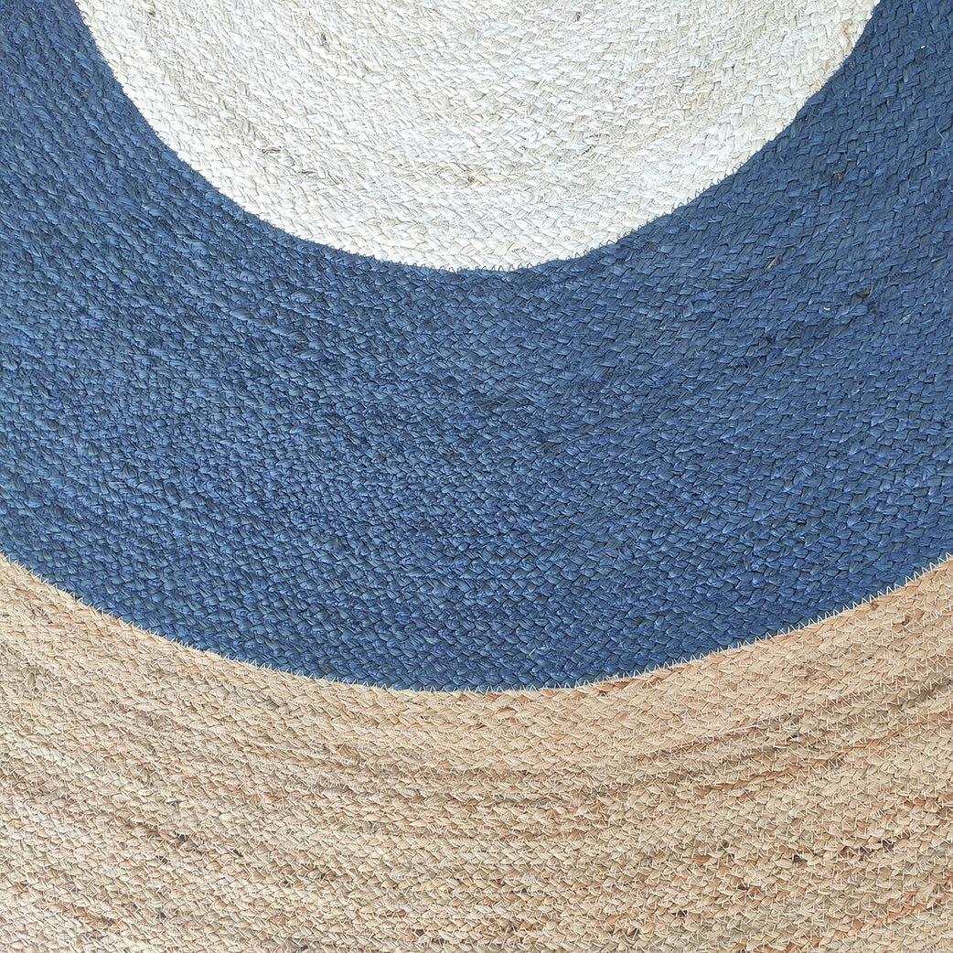 The Amazing Handmade Braided Jute Floor Round Rug - BR 074 (200 cm) by RAMSHA HOME features concentric sections in natural beige, dark blue, and off-white, blending blue and natural tones for a stylish circular accent.