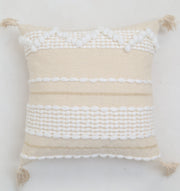 The Cream Color Home Decor Cushion - CS 313 B by Ramsha Home features textured white patterns, stripes, pom-pom details, and corner tassels for a neutral boho style—perfect for elevating your décor.