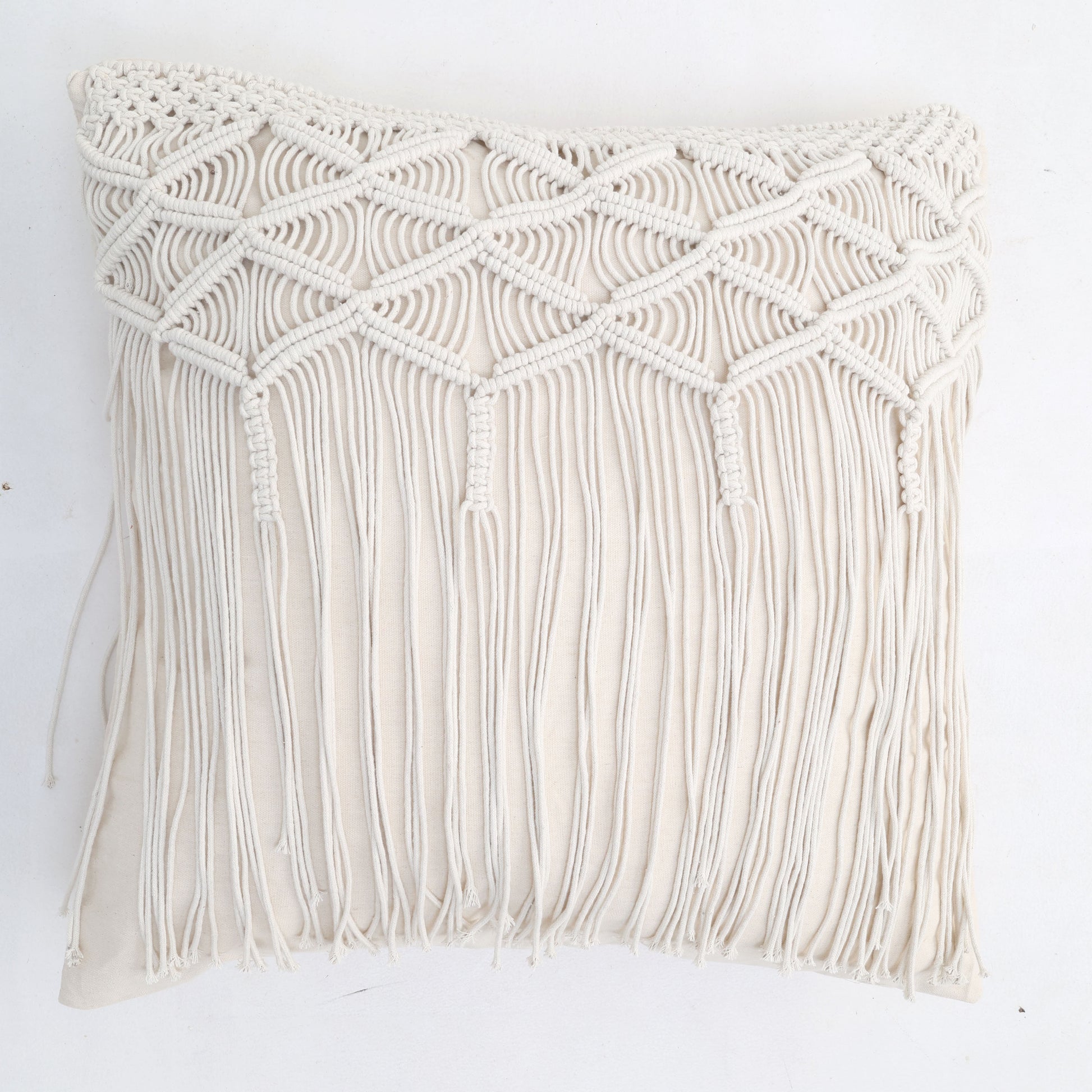 The Natural White Macrame Sofa Cushion - CS 309 by Ramsha Home features a handcrafted macramé cover with diamond patterns and long fringe, making it stand out against a white background.