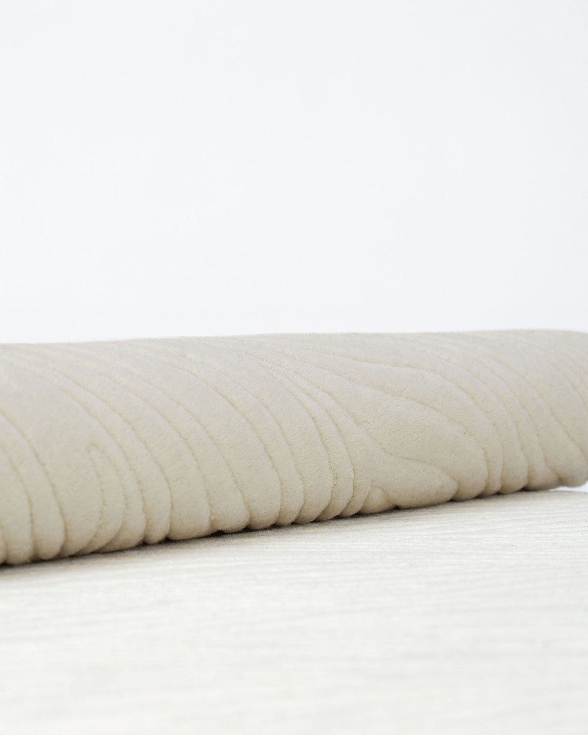 A close-up of the RAMSHA HOME Natural White Color Area Carpet - HTW 88 showcases its textured, wavy pattern in a subtle natural white hue, resting gracefully against a plain white background. This elegant carpet evokes the soft sophistication of an ivory accent piece, bringing modern neutral style to any space.