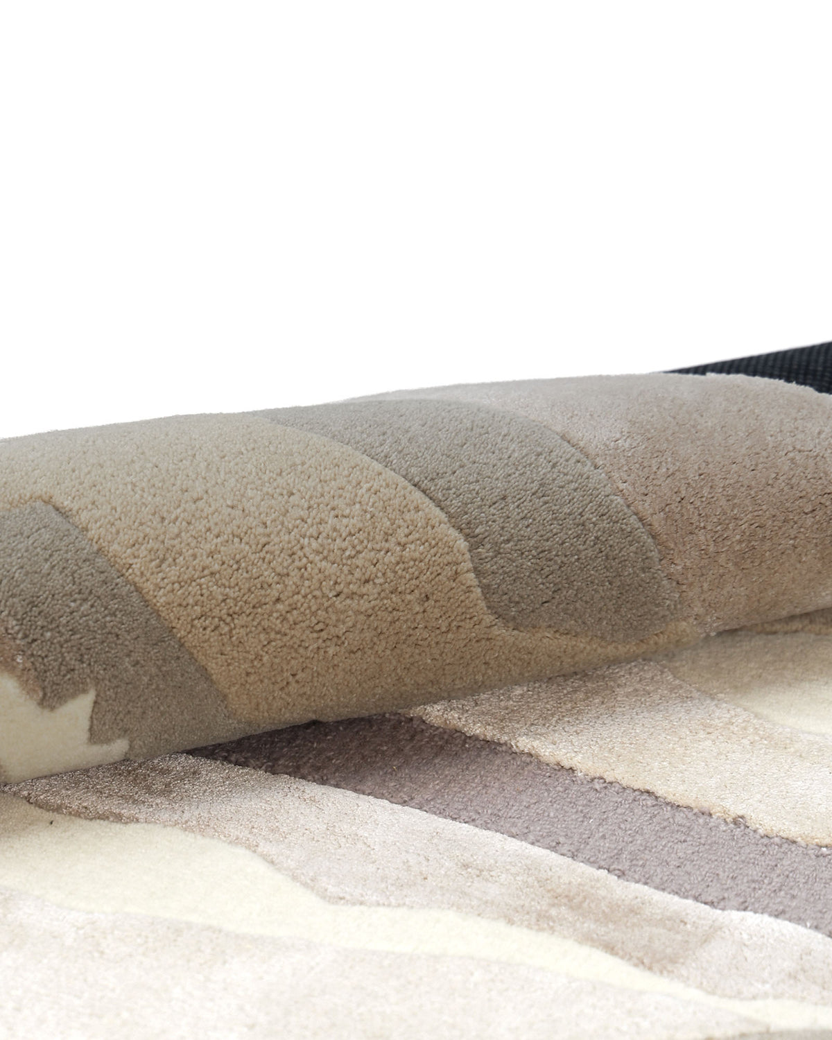 A close-up of the RAMSHA HOME Abstract Wool & Viscose Handmade Carpet 200x300 – HTWV-179, featuring a rolled-up multicolored beige and brown design with soft, plush texture and organic wave-like patterns.