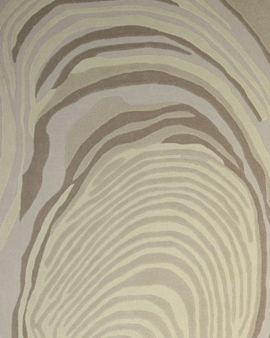 The Terra Eclipse Oval Handmade Rug Accent Rug HTW-155 by RAMSHA HOME features an abstract pattern of wavy, concentric lines in beige and brown tones—reminiscent of tree rings or a fingerprint on a textured surface—making it an eye-catching addition to any space.