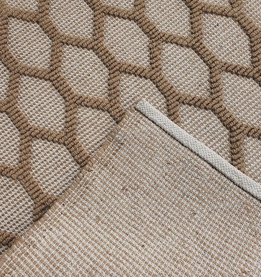 A close-up of the RAMSHA HOME Rectangle Woven Area Rug Neutral Beige And Brown SR-023, featuring a geometric honeycomb pattern. One corner is folded over to show the woven underside and detailed edge stitching.