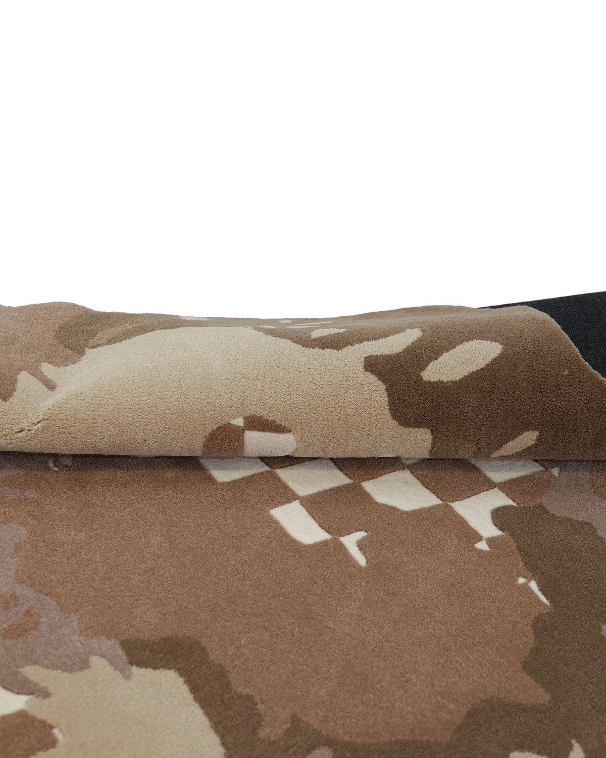 A close-up of folded fabric featuring a brown, tan, and beige camouflage pattern with checkered accents, reminiscent of the Handmade Multicolor Area Bespoke Rug HTW 128 (200cm) by RAMSHA HOME.