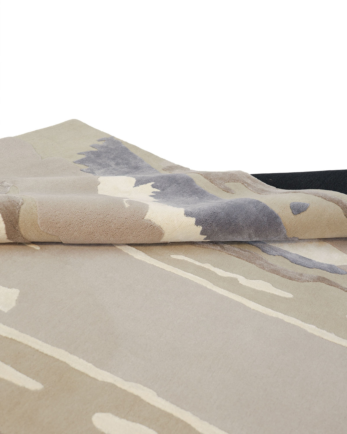 A close-up of the folded Classic Rectangle Handmade Area Rug- HTWV 177 (300x400 cm) by RAMSHA HOME highlights its abstract, hand-tufted viscose design in beige, cream, gray, and taupe tones displayed on a plain surface.