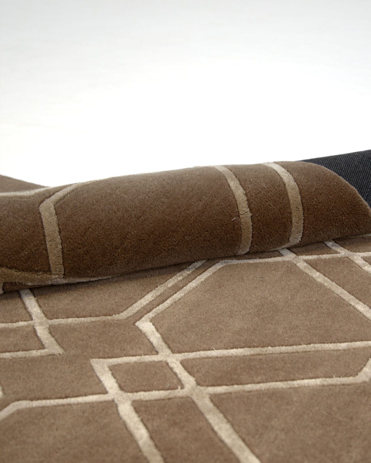 A close-up of the RAMSHA HOME Stunning Multi Color Hand-Tufted Rug HTWV 21, featuring a modern geometric pattern in beige lines, with one corner slightly lifted to reveal its underside.