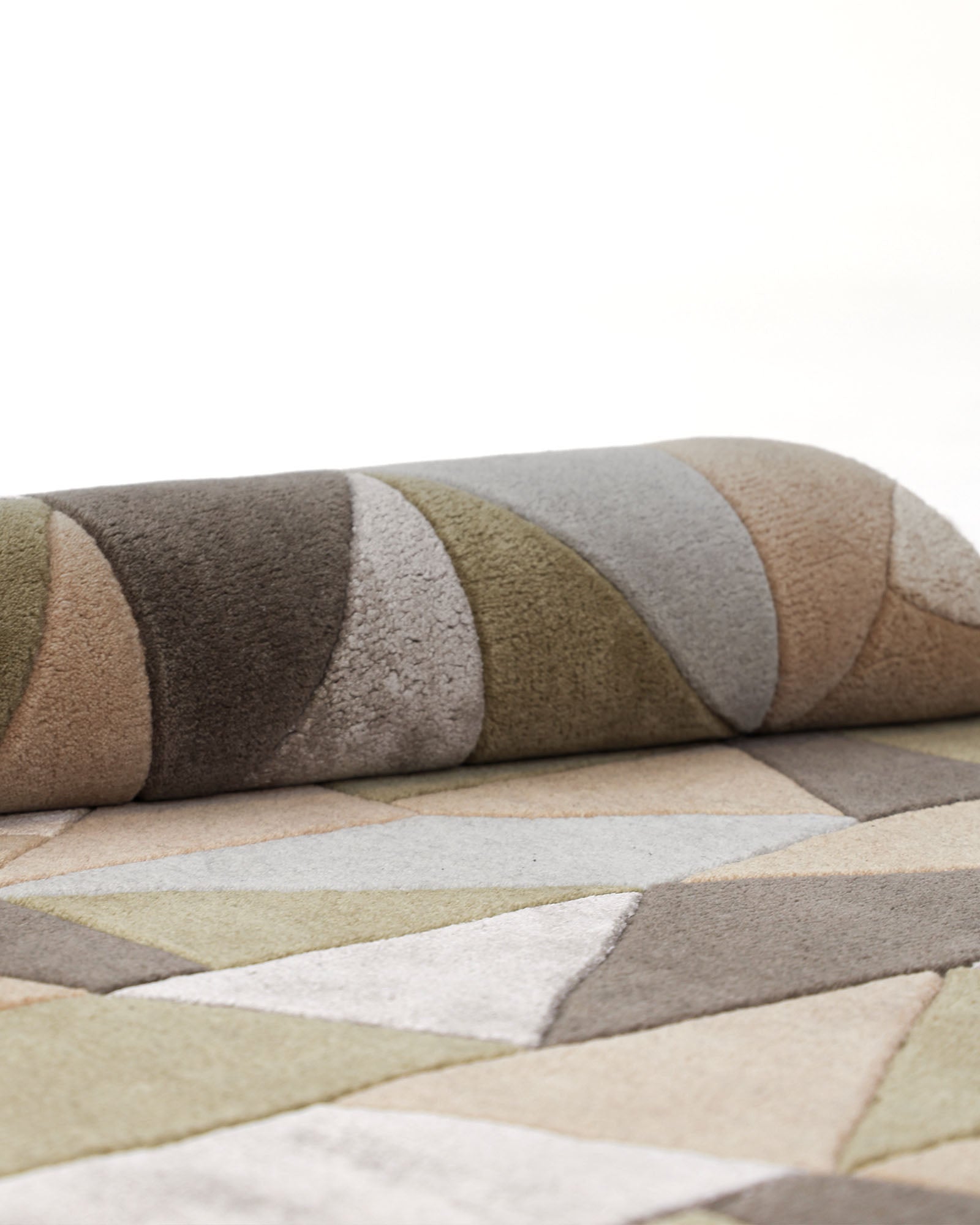 A close-up of the RAMSHA HOME Handmade Round Carpet For Home Decor 200 CM HTWV-47, showcasing hand-tufted geometric patterns in muted shades of green, beige, brown, and gray on a light background.