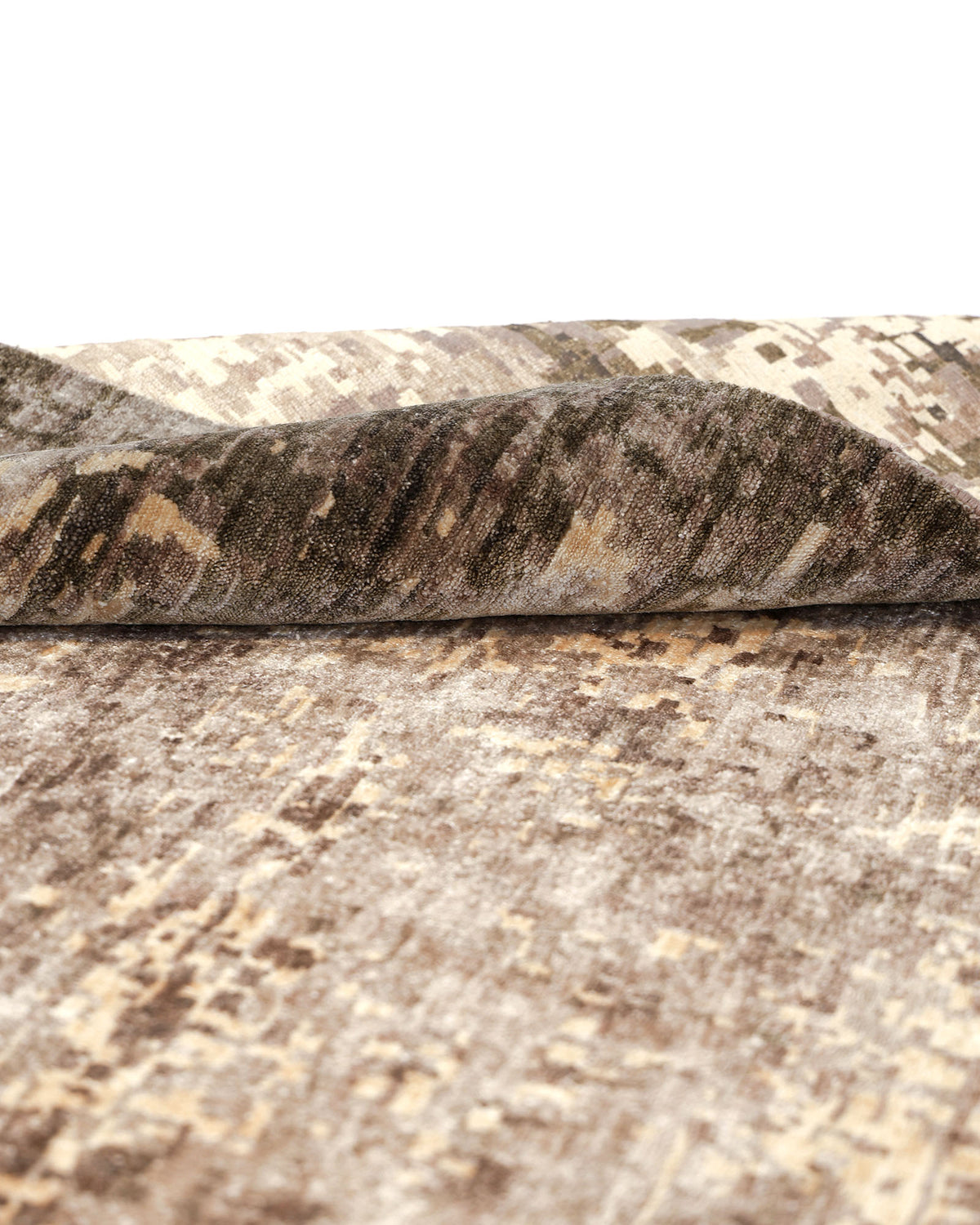 A close-up of the RAMSHA HOME Hand knotted Living Room Rug - HKWB-013 showcases its modern distressed design in shades of brown and beige, with one corner partially folded to reveal the underside. This hand knotted rug features a mottled, abstract pattern, adding depth and texture to any space.