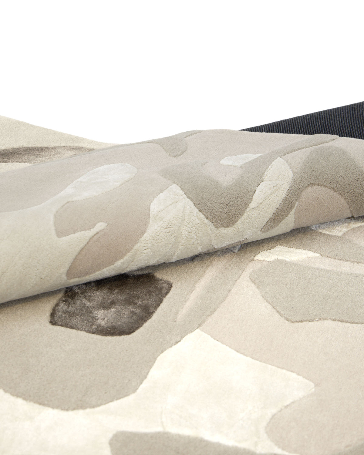 A close-up of the RAMSHA HOME Abstract Wool & Viscose Handmade Carpet 300x400 – HTWV-180, partially folded to reveal its soft hand-tufted texture and a sophisticated blend of beige, cream, and brown abstract patterns.