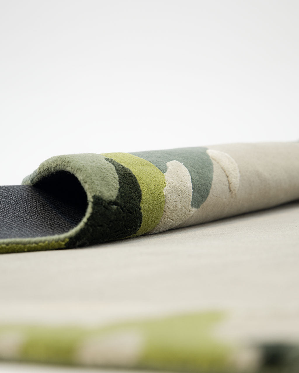 A close-up of the RAMSHA HOME Terra Eclipse Oval Handmade Rug Accent Rug HTWV-201, showcasing its soft, textured surface with green, beige, and cream abstract patterns on a light background—perfect as a modern interior accent rug to bring subtle elegance to any space.