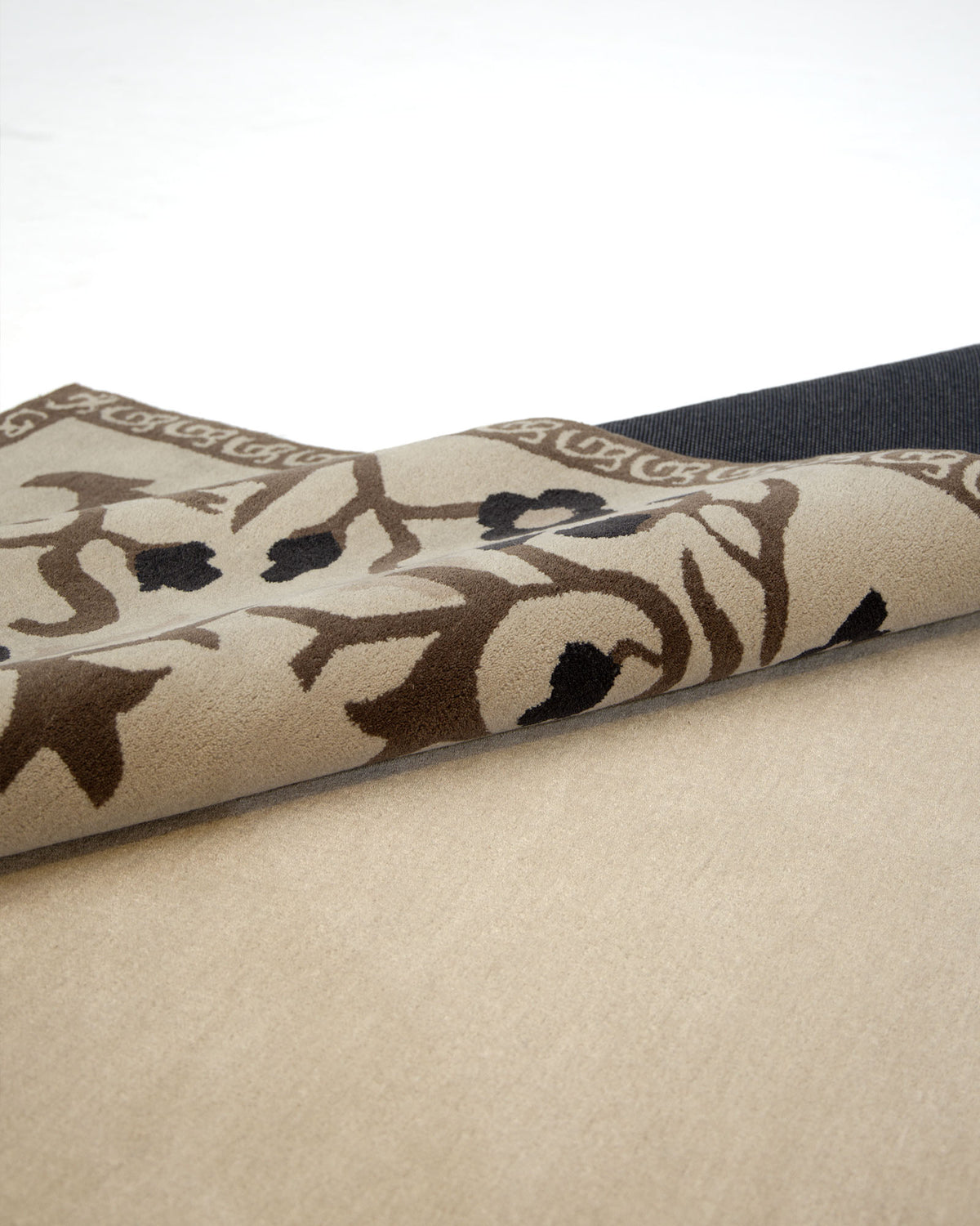 A multi-color handmade carpet (300X400 CM, model HTW-05) by RAMSHA HOME, featuring a floral design, is partially rolled on a light-colored carpet, exposing its dark backing.