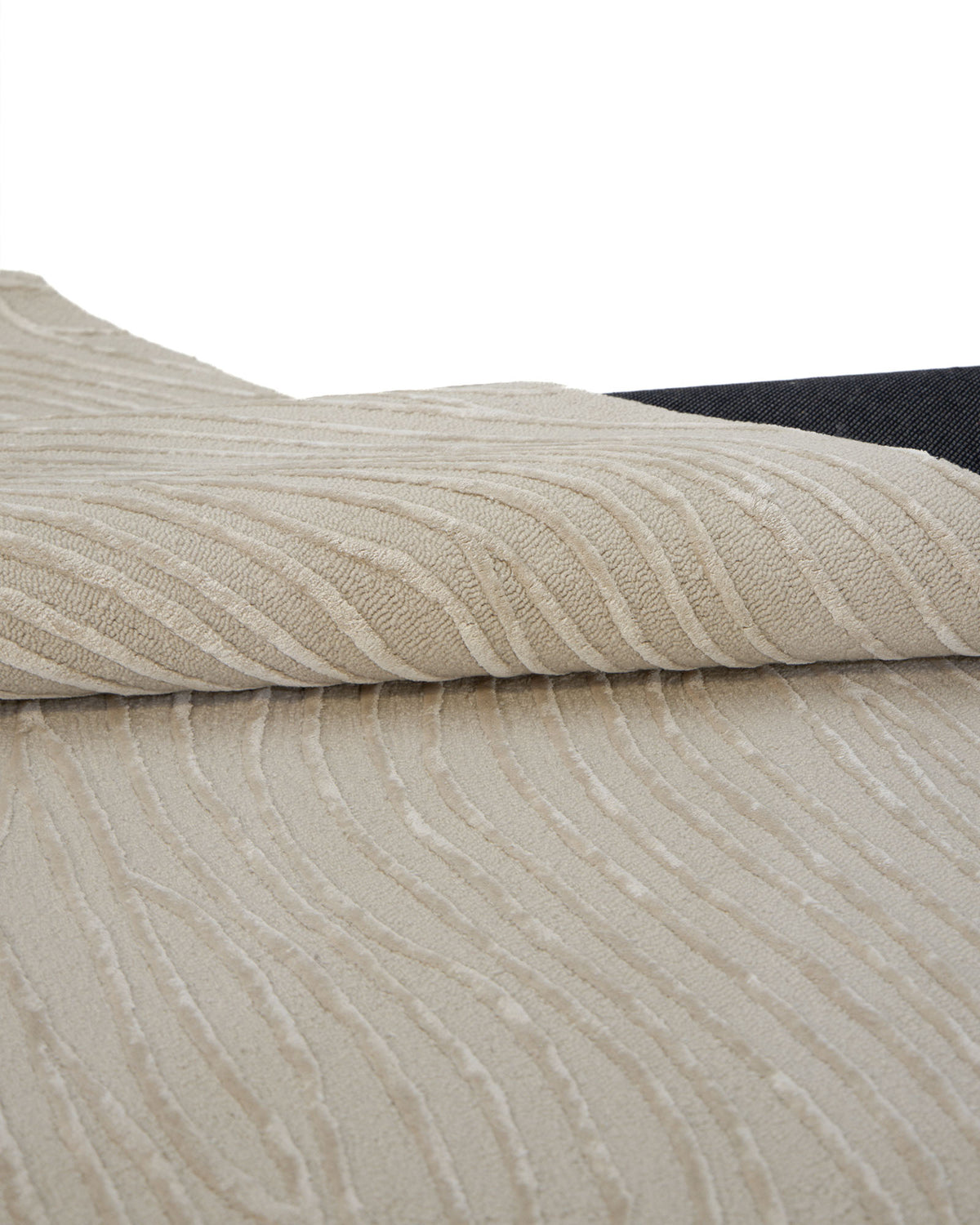 A close-up of the RAMSHA HOME Natural White Color Handmade Area Rug (HTWV-143, 300x400 cm) reveals its delicate abstract wavy patterns and expertly hand-tufted wool craftsmanship. Partially rolled to show its dark backing, this textured area rug brings depth and sophistication to any space.