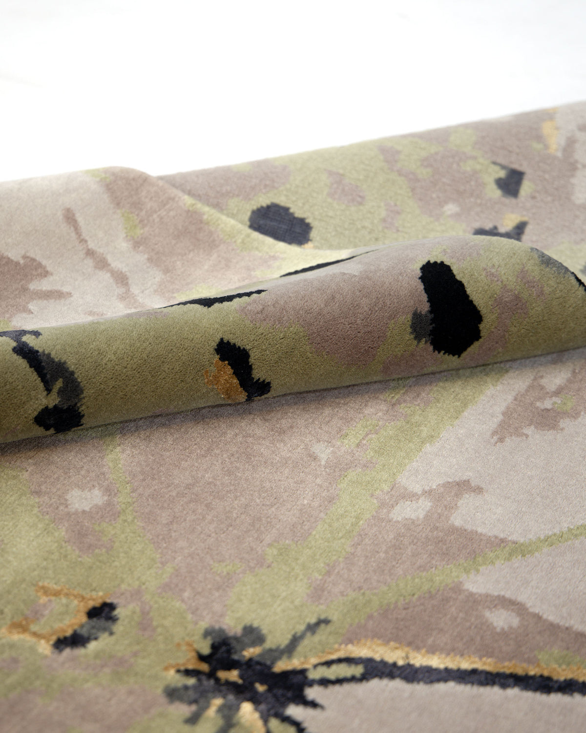 A close-up of the RAMSHA HOME Butterfly Design Carpet For Every Room HKWV-010, featuring a beige and green abstract pattern in Tencel wool, partially rolled on a light surface.