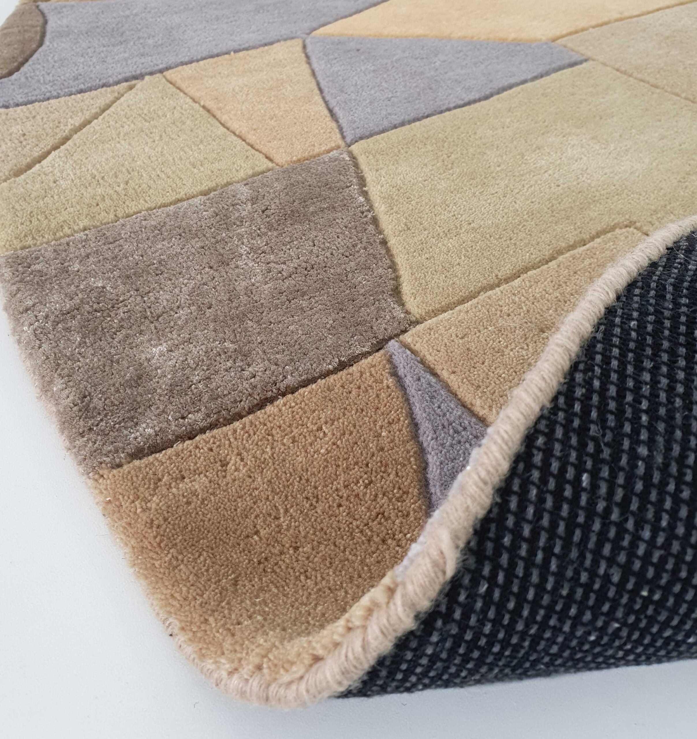 A close-up of the RAMSHA HOME Vibrant Multi Color Round Handmade Rug - HTWV 50 (200cm) highlights its geometric pattern and lifted corner, revealing a black textured non-slip backing.