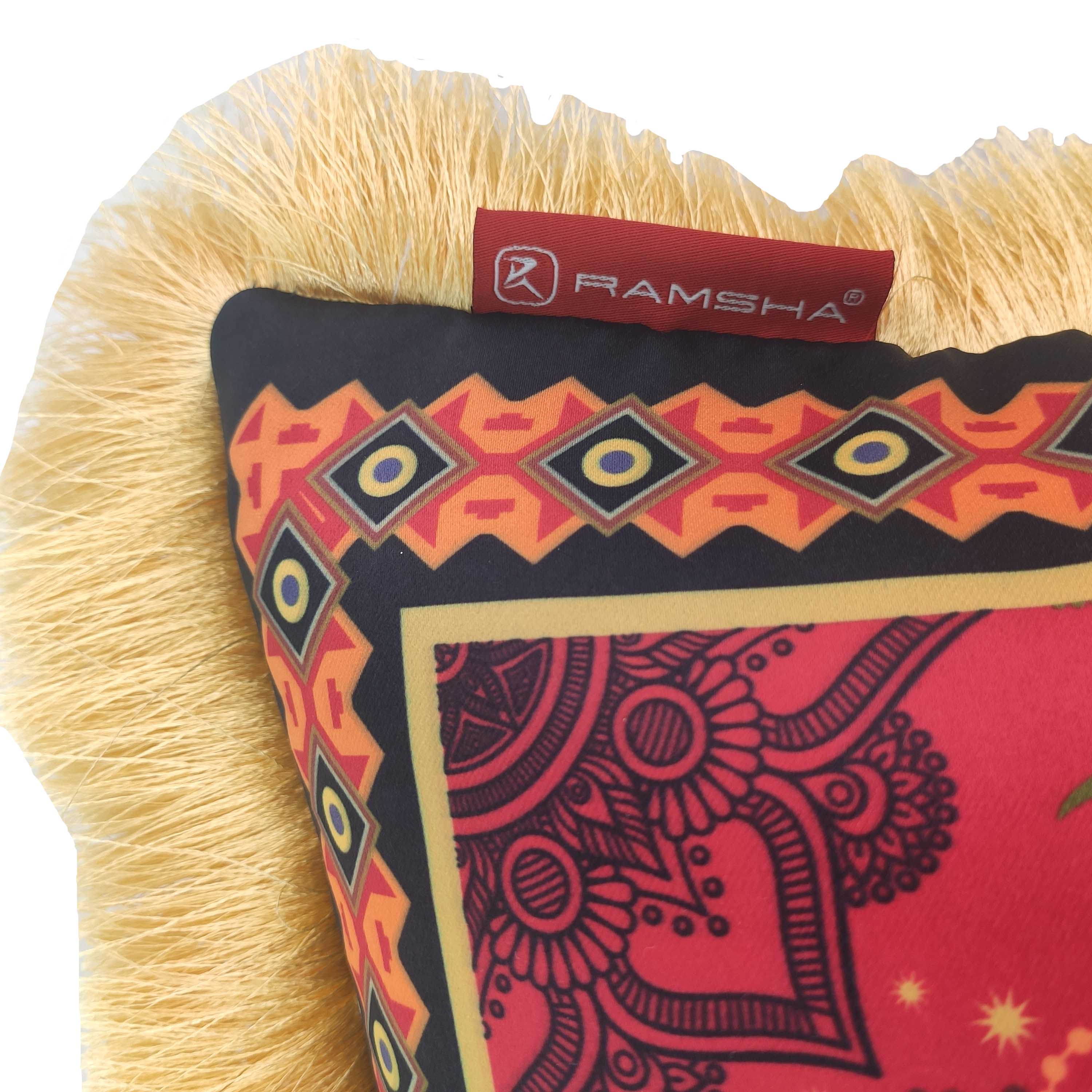 A close-up of the Home Decorative Cushion With Filler CS-060 by RAMSHA HOME, featuring a red and black geometric and floral pattern, yellow fringe, plush filling, and a red tag labeled RAMSHA HOME on one corner.