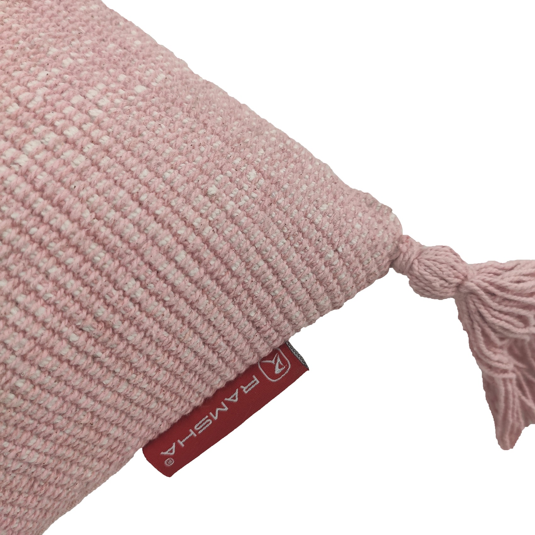Close-up of RAMSHA HOME's Cotton Cushion With Fringes CS-133 in pink, featuring a corner tassel and a red “RAMSHA” tag. The high-quality filler ensures comfort, displayed on a white background.