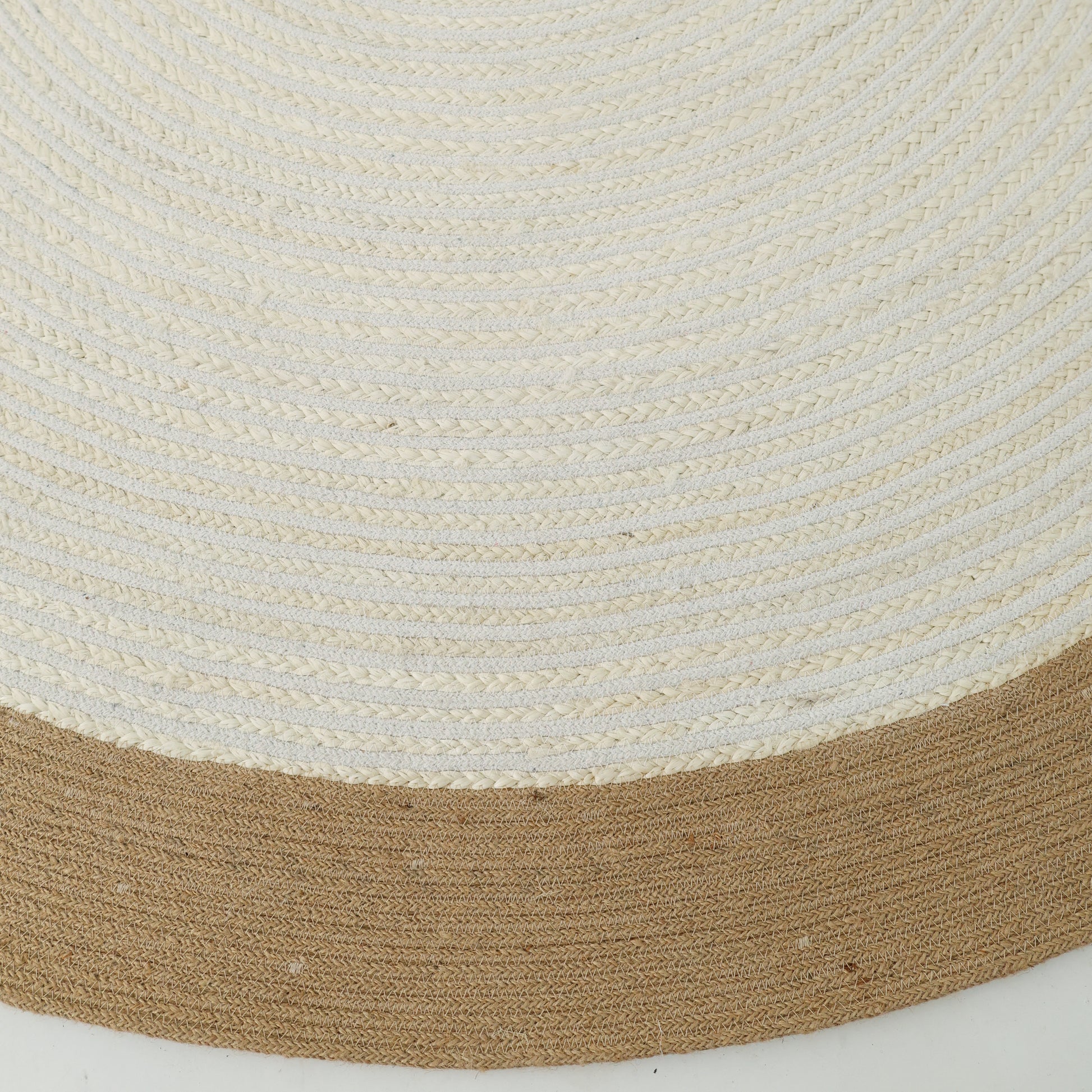 A close-up of the Home Decor Round Jute Rug - BR 089 shows its woven beige pattern and thick brown border along the edge.
