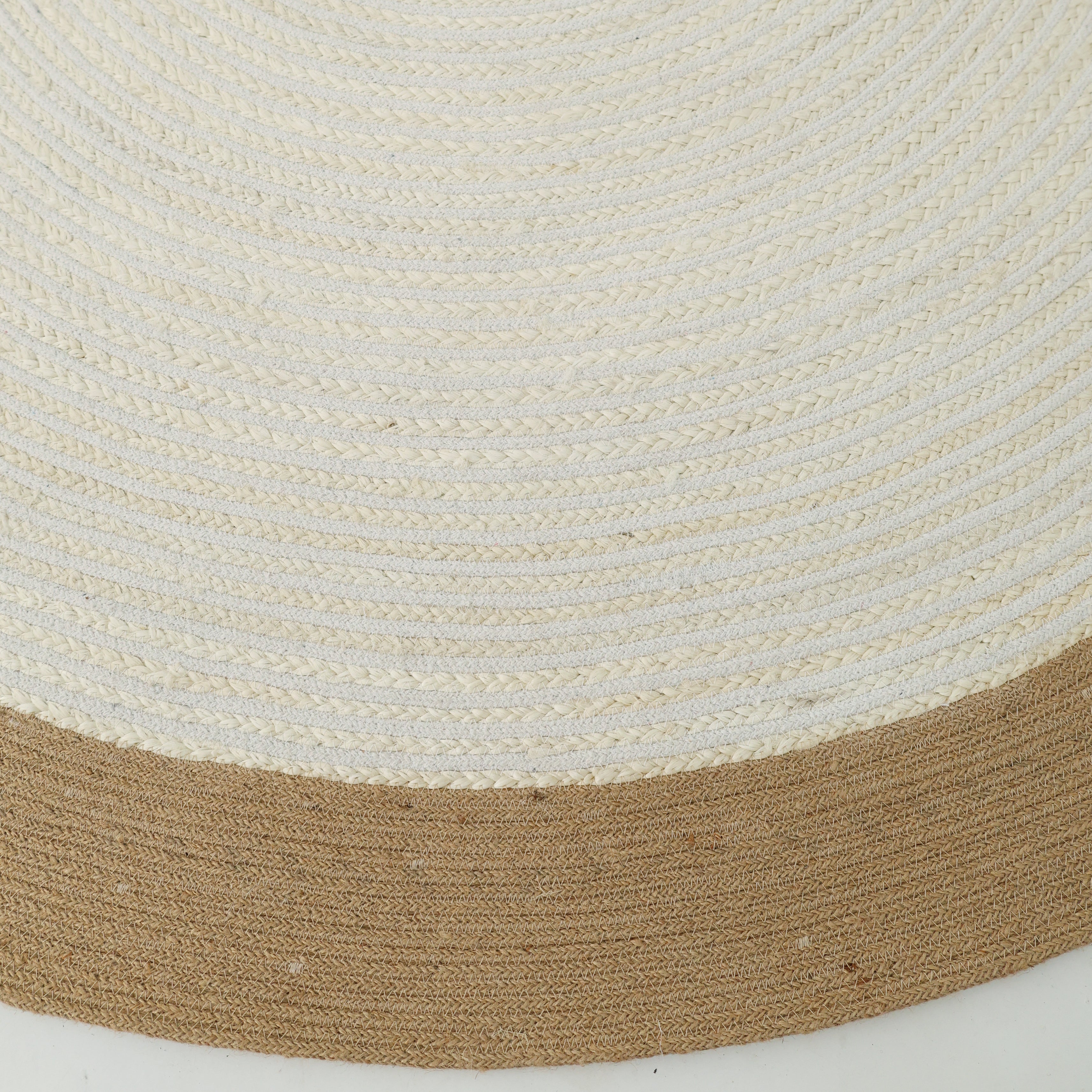 A close-up of the Home Decor Round Jute Rug - BR 089 shows its woven beige pattern and thick brown border along the edge.