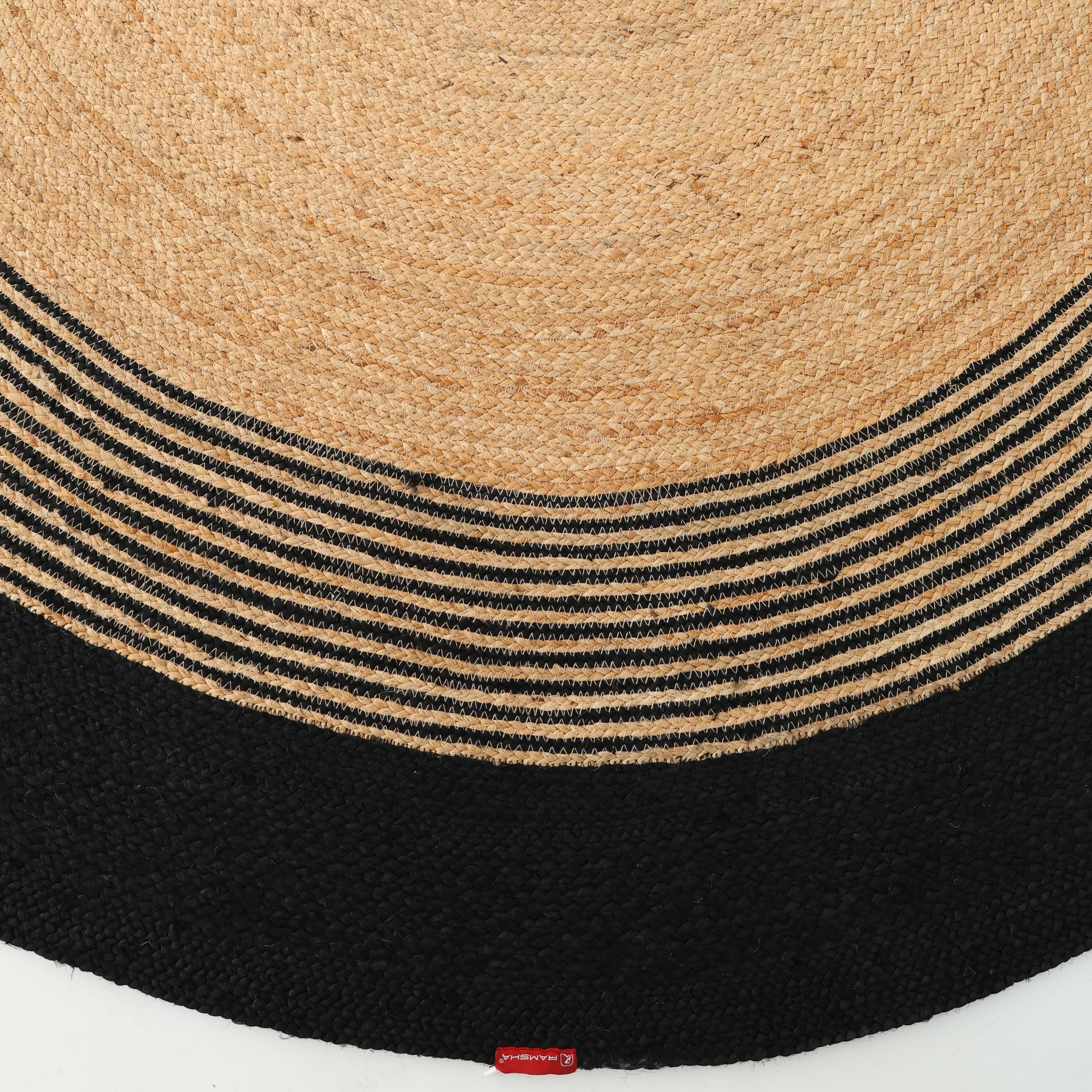 The Luxurious Handmade Braided Jute Round Rug - BR 028 by RAMSHA HOME features concentric circles with a natural tan center, alternating tan and black stripes, and a solid black border.