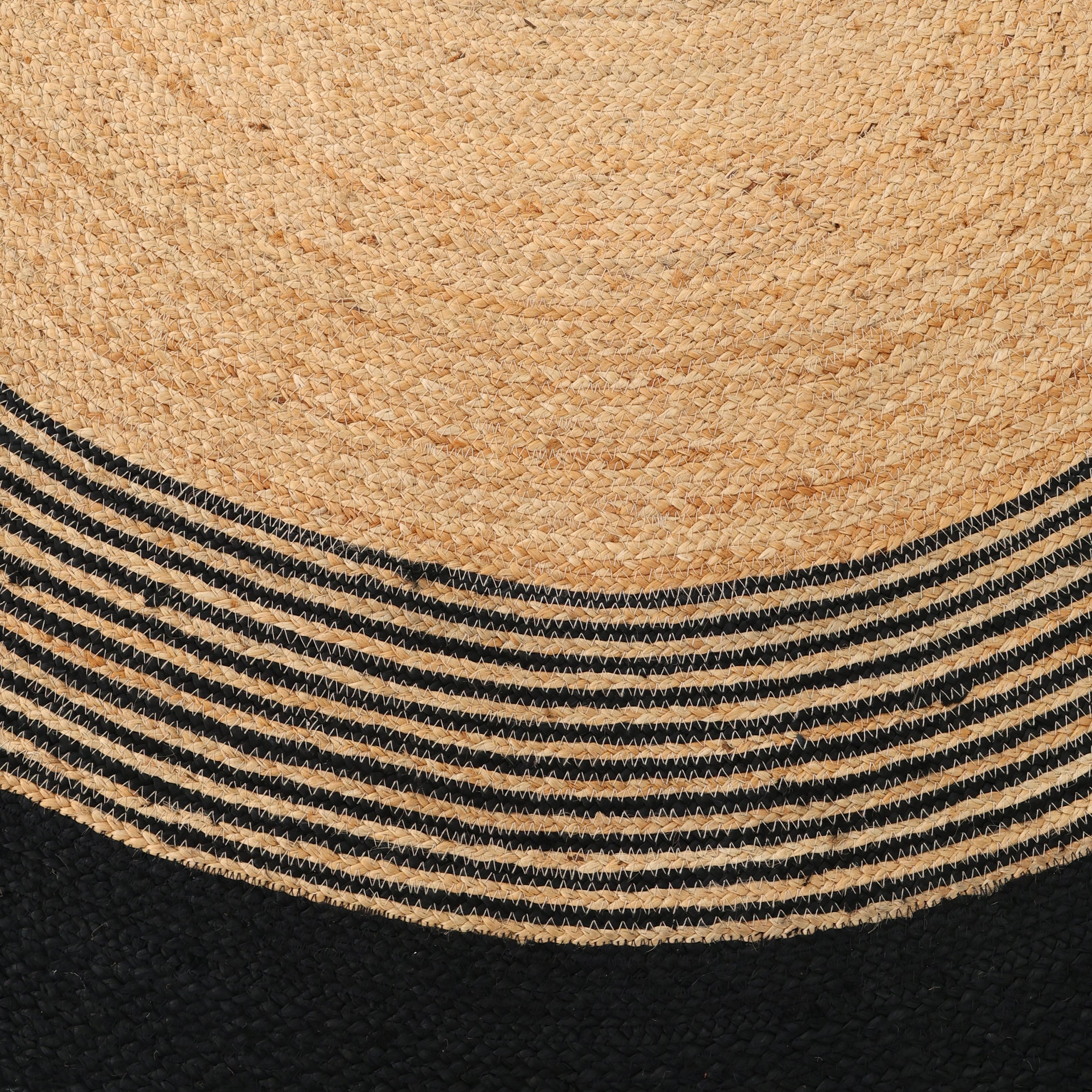 A close-up of the Luxurious Handmade Braided Jute Round Rug - BR 028 by RAMSHA HOME, showcasing a natural tan top, black bottom, and concentric black and tan stripes—a stunning round jute rug.