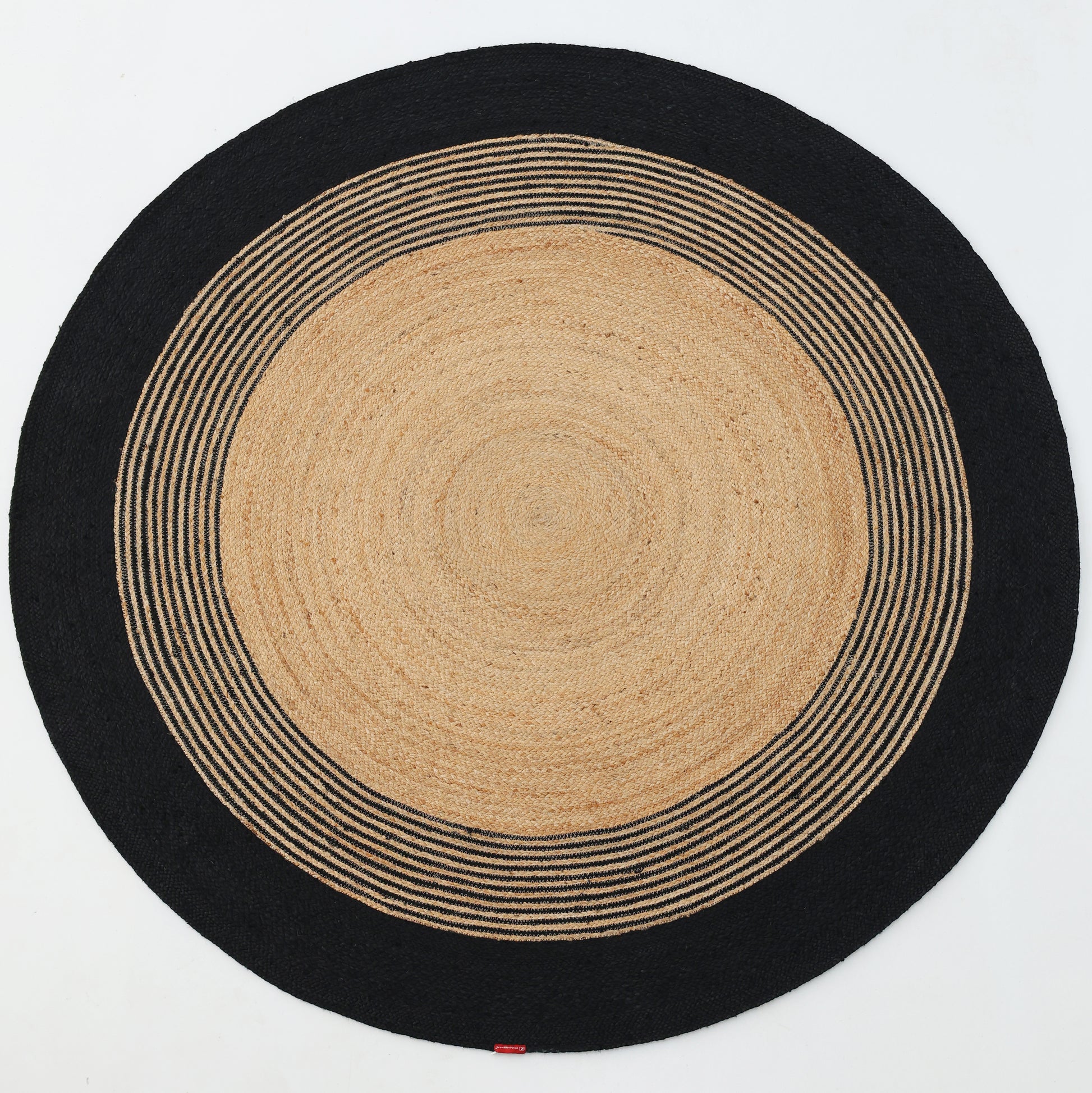 The RAMSHA HOME Luxurious Handmade Braided Jute Round Rug - BR 028 features a natural tan center, concentric black and tan stripes, and a solid black border—bringing timeless style to any space.