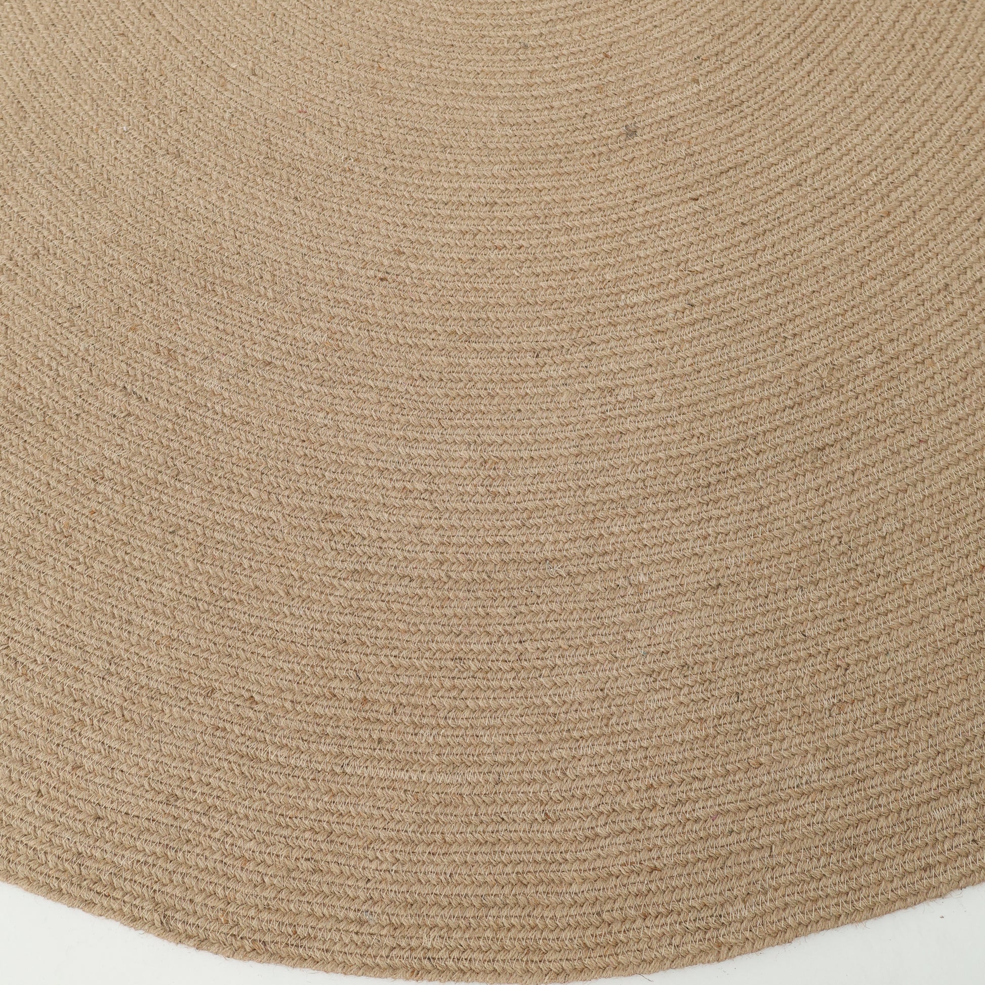 Close-up of the RAMSHA HOME Stunning Handmade Jute Indoor & Outdoor Round Braided Rug - BR 014, displaying its concentric circular patterns and tightly braided natural fibers against a white background.