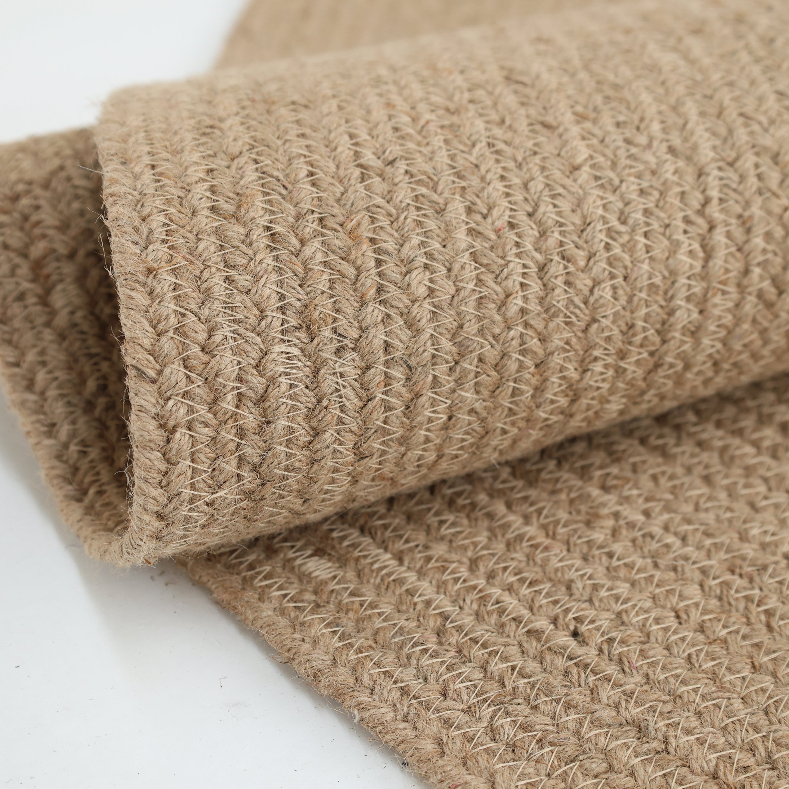A close-up of the RAMSHA HOME Stunning Handmade Jute Indoor & Outdoor Round Braided Rug - BR 014, highlighting its beige textured pattern and thick, sturdy natural fiber threads.