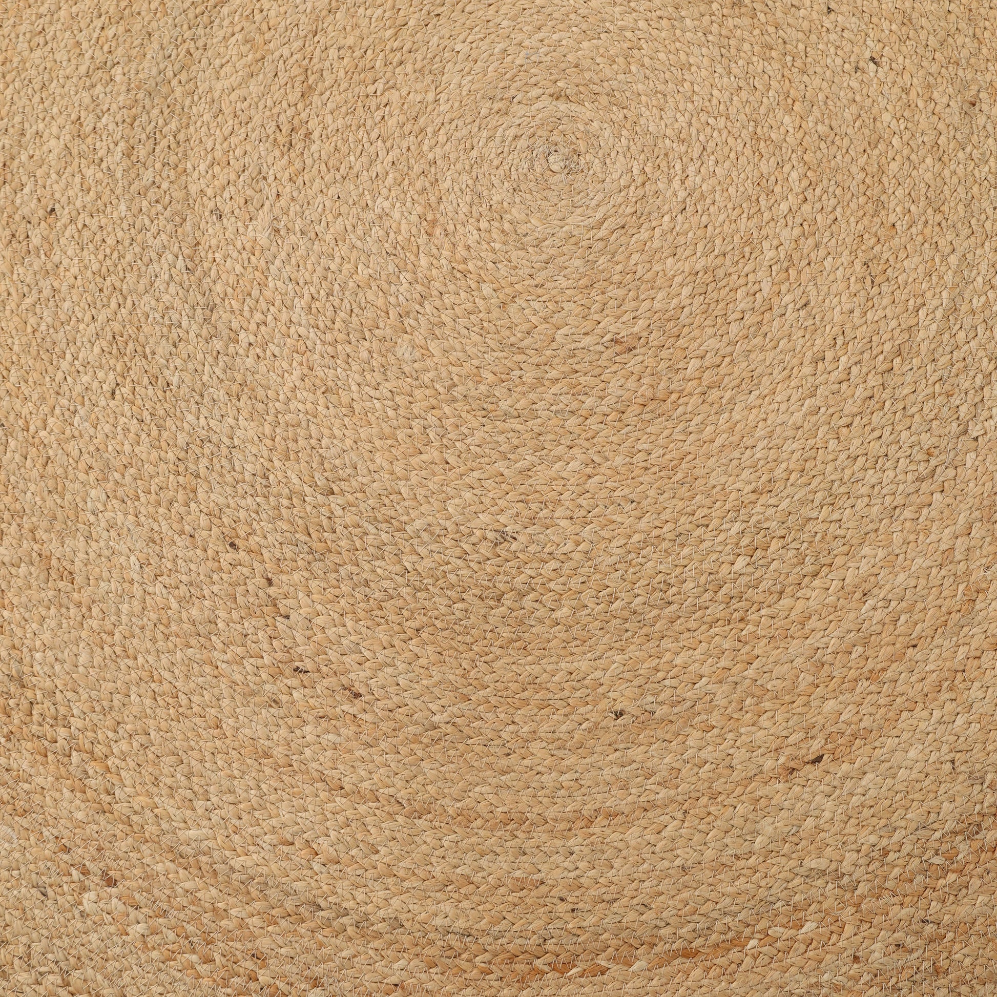 A close-up of the RAMSHA HOME Handmade Natural Color Braided Round Rug - BR 013 highlights its beige spiral pattern and textured, woven natural fiber surface.