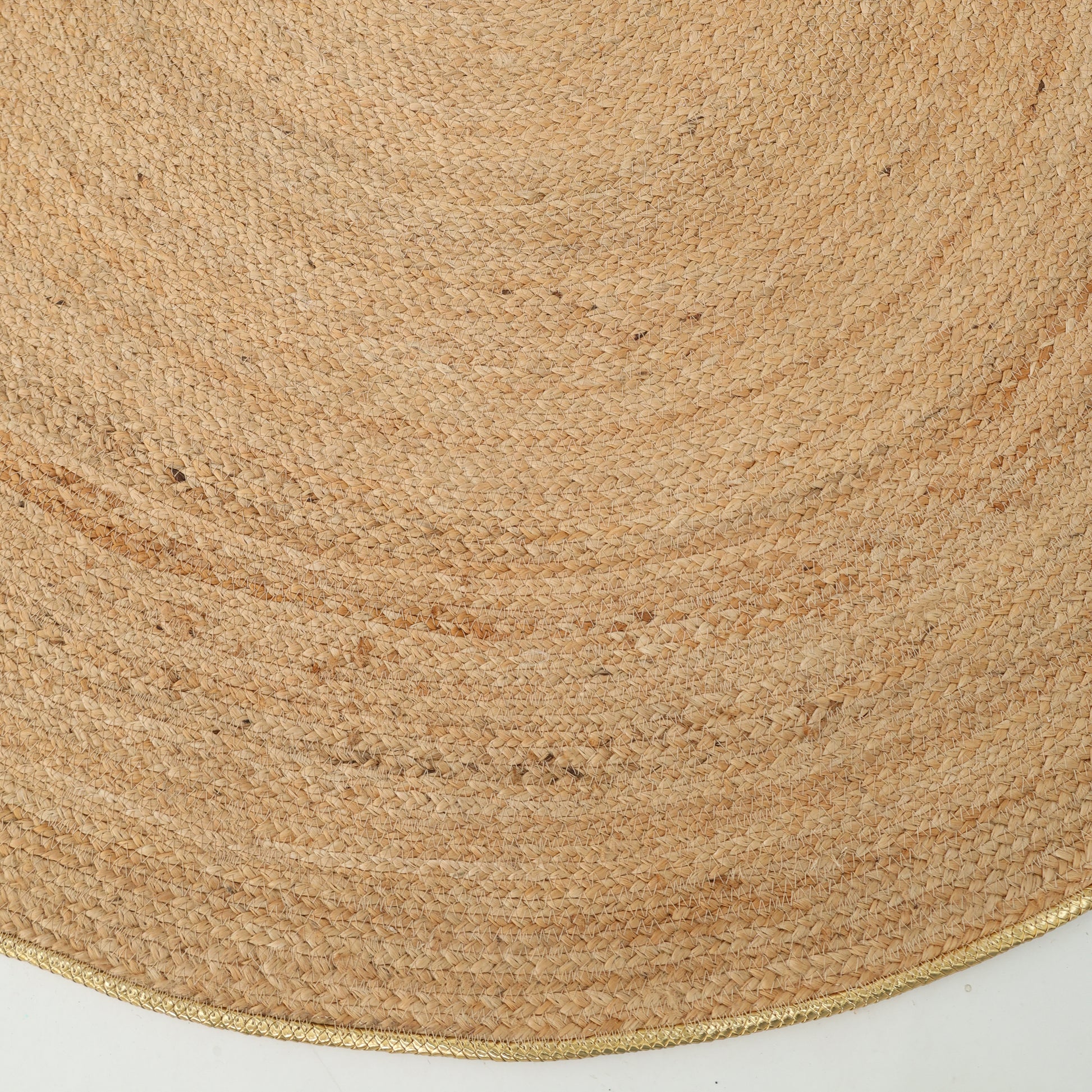 Close-up of the RAMSHA HOME Handmade Natural Color Braided Round Rug - BR 013, featuring a circular woven design with natural fibers; part of its curved edge is shown against a white background.