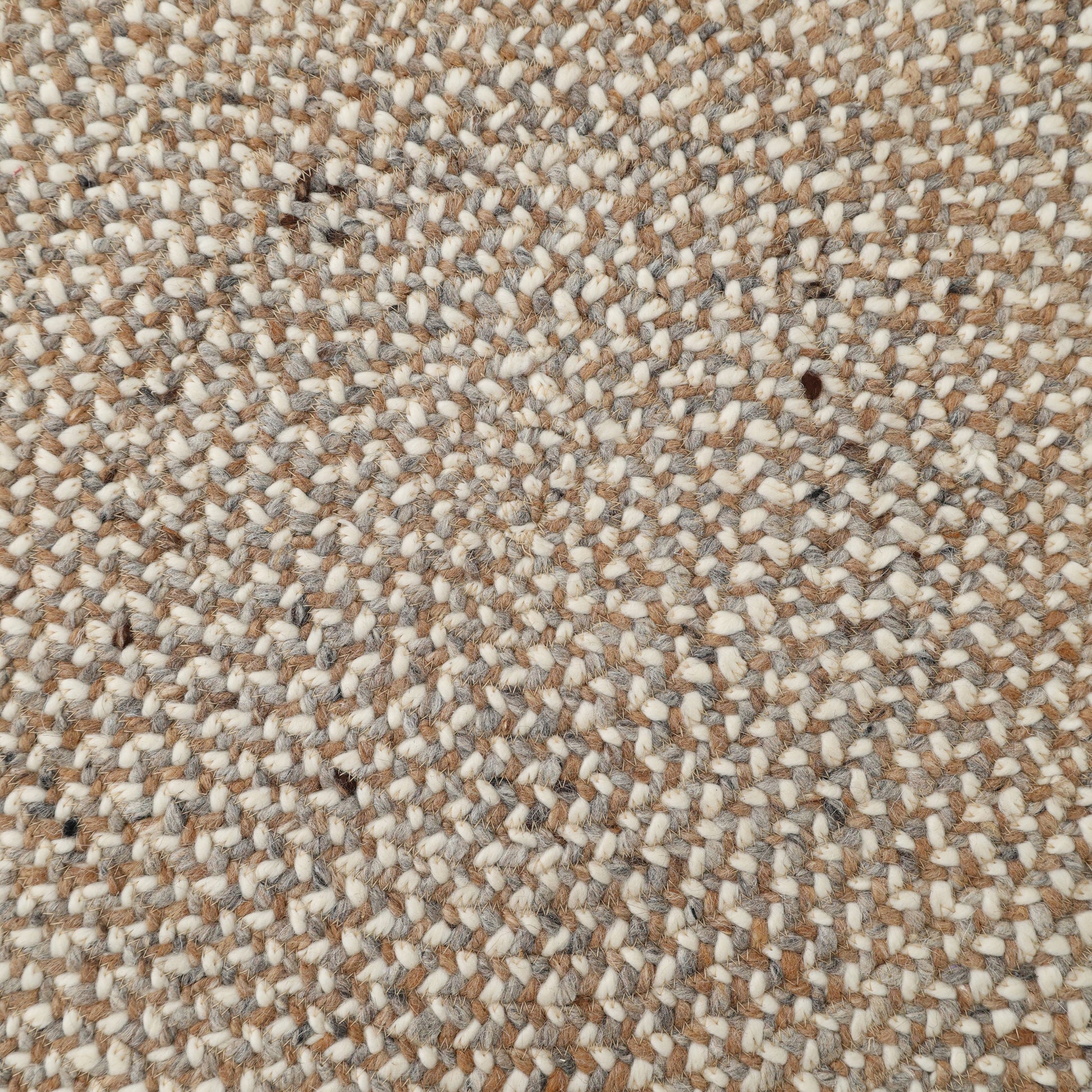 Close-up of the RAMSHA HOME Natural Color Dining Room Jute Area Braided Rug - BR 096, showcasing its beige, cream, grey, and light brown braided texture—perfect for adding warmth to any modern minimalist space.