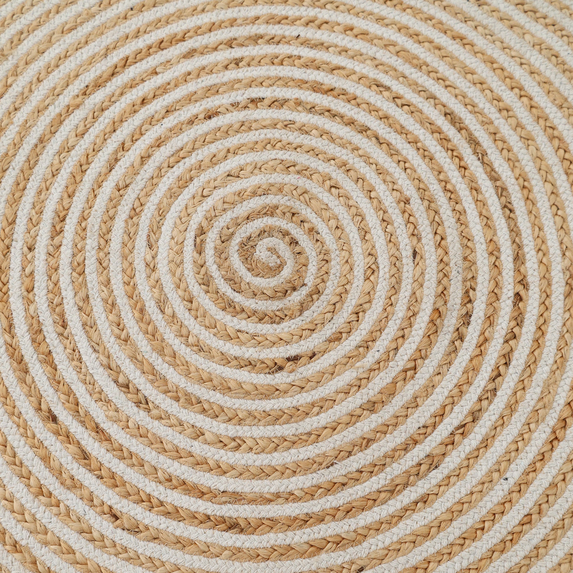 The Handmade Natural & White Color Braided Jute Round Rug - BR 012 features tightly coiled beige and white jute in a circular, spiral pattern, creating a textured and symmetrical design reminiscent of classic round rugs.